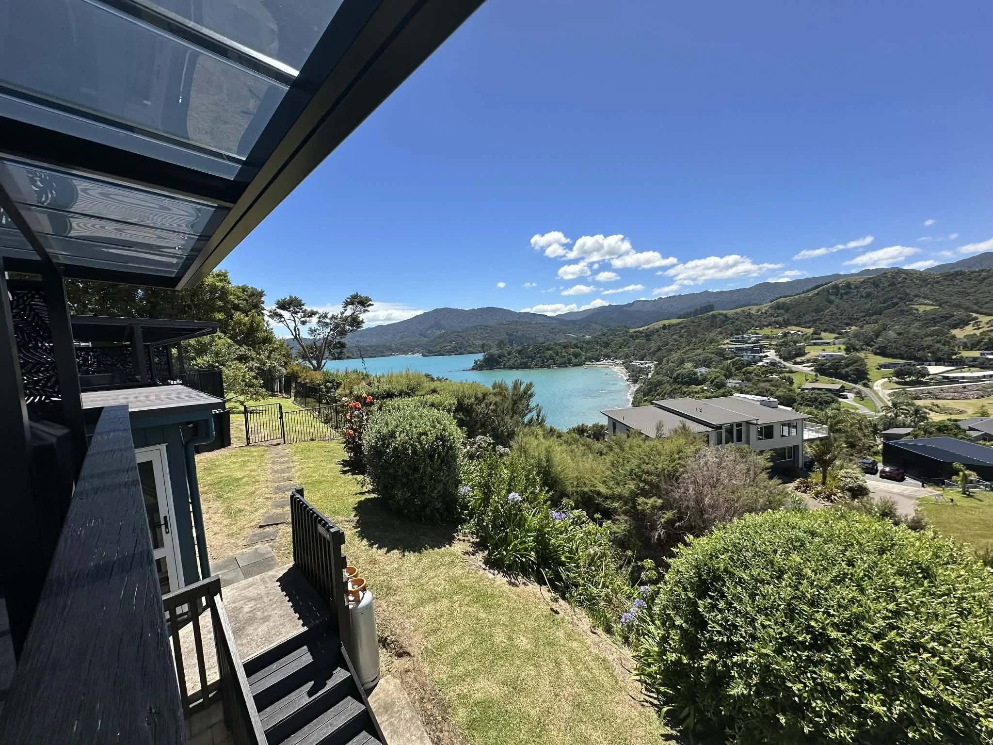 The Deluxe Studio’s private balcony offers stunning views over the turquoise bay, beach, and surrounding hills — a peaceful spot to relax and take in Coromandel’s beauty.