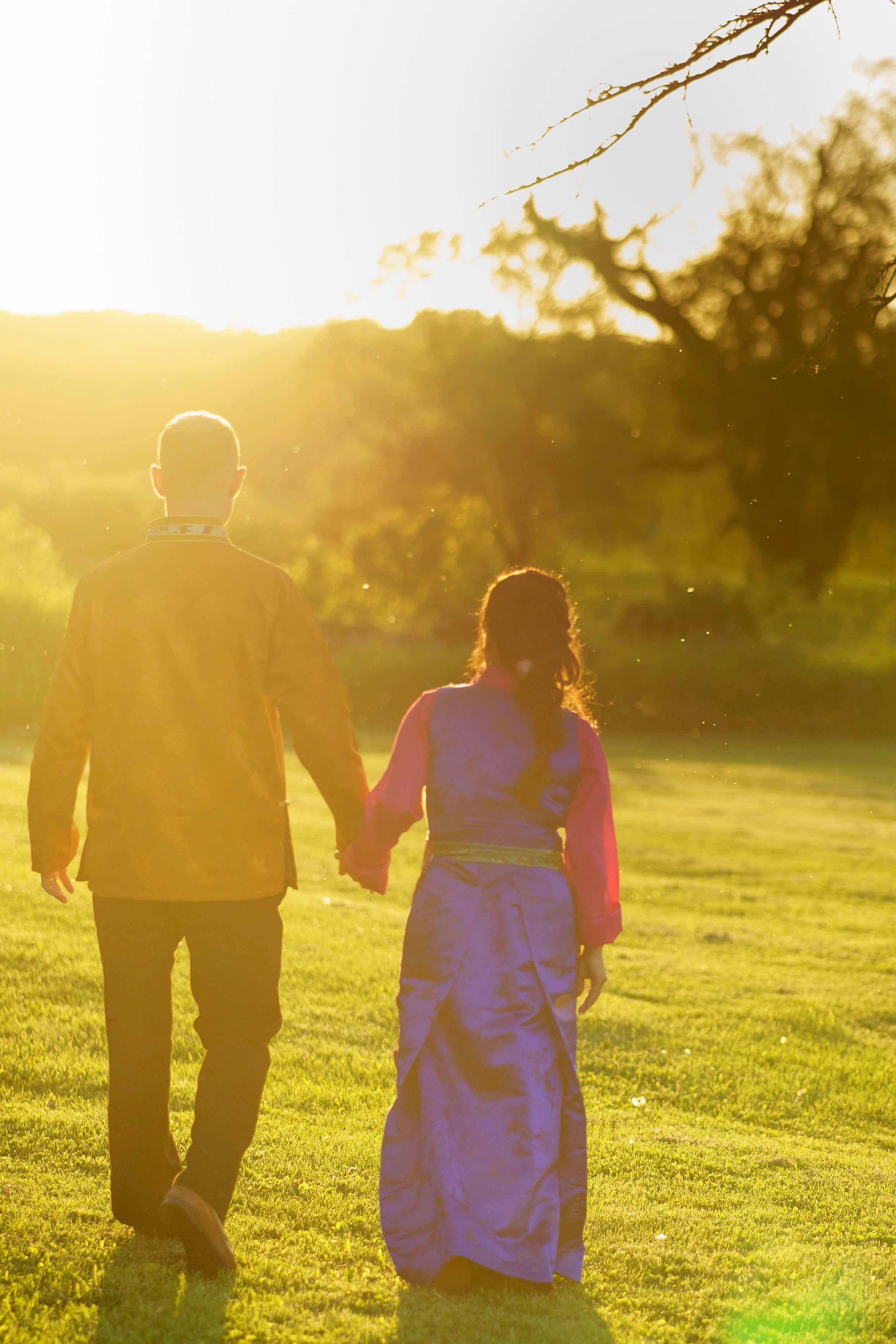 bride and groom walk into golden hour sunset wearing Nepali wedding attire photograph by Life Times Photography 
