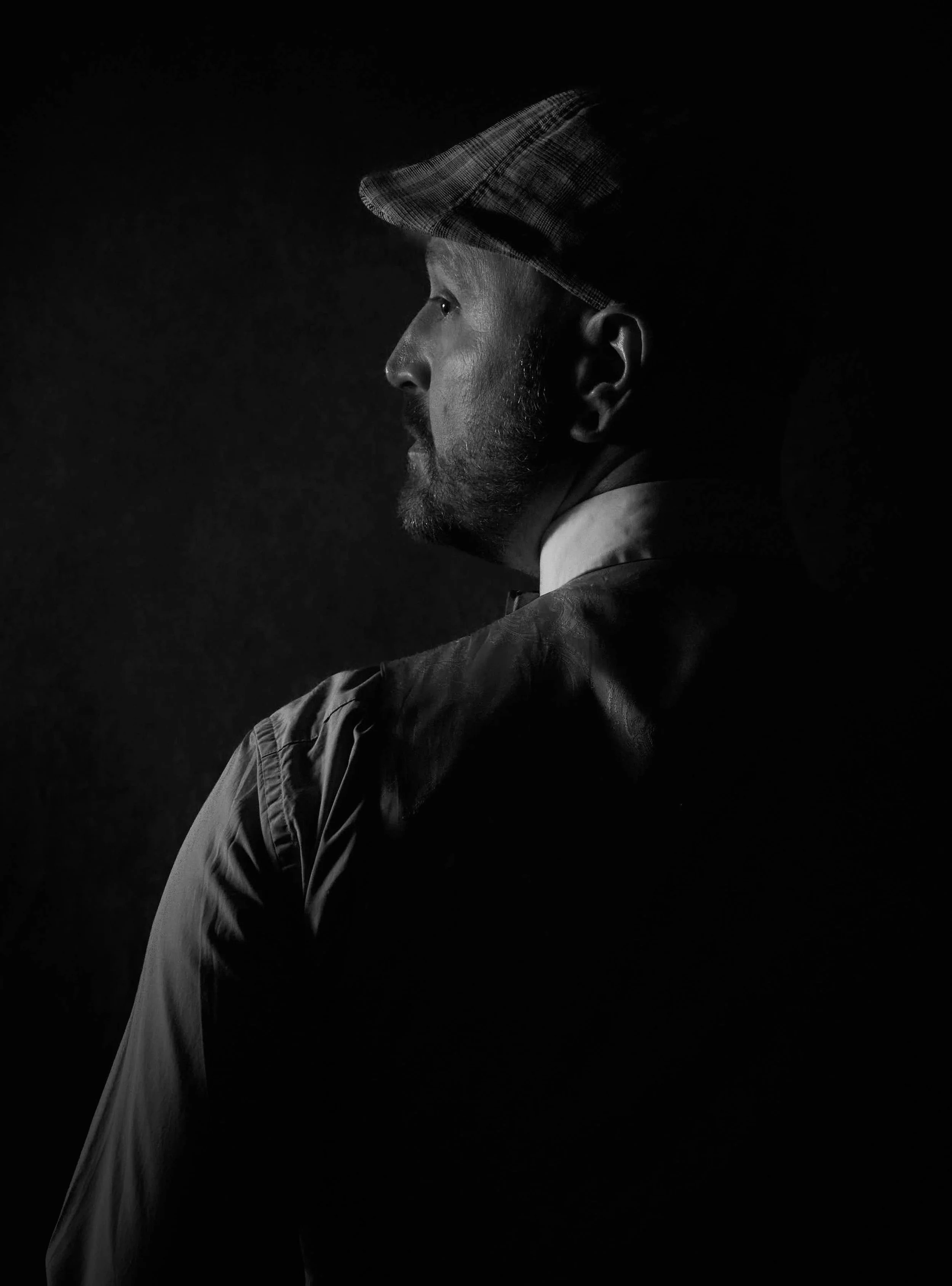 monochrome man in dapper outfit looking over his left shoulder photograph by Life Times Photography