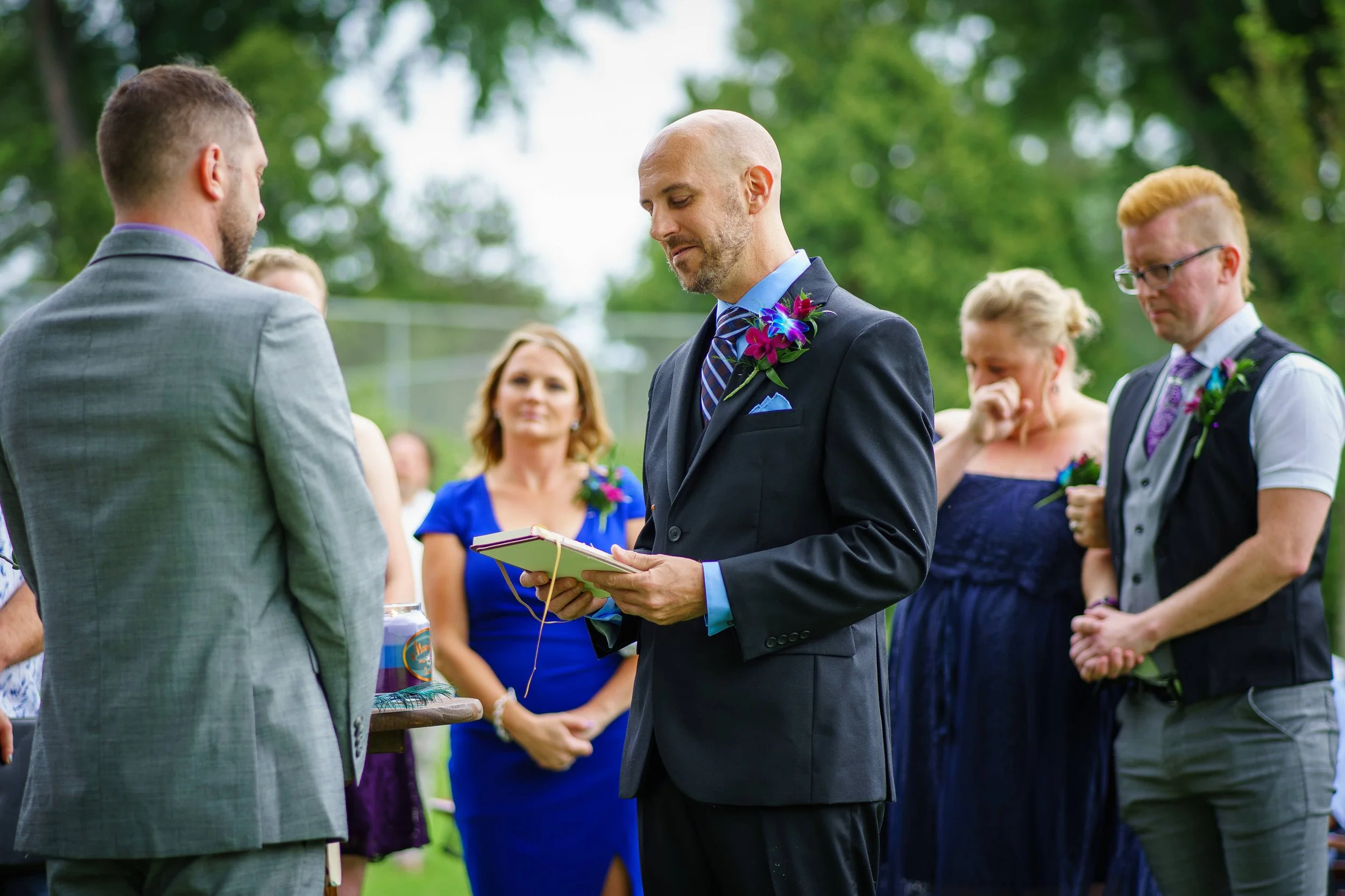 same sex couple read vows during wedding ceremony photograph by Life Times Photography
