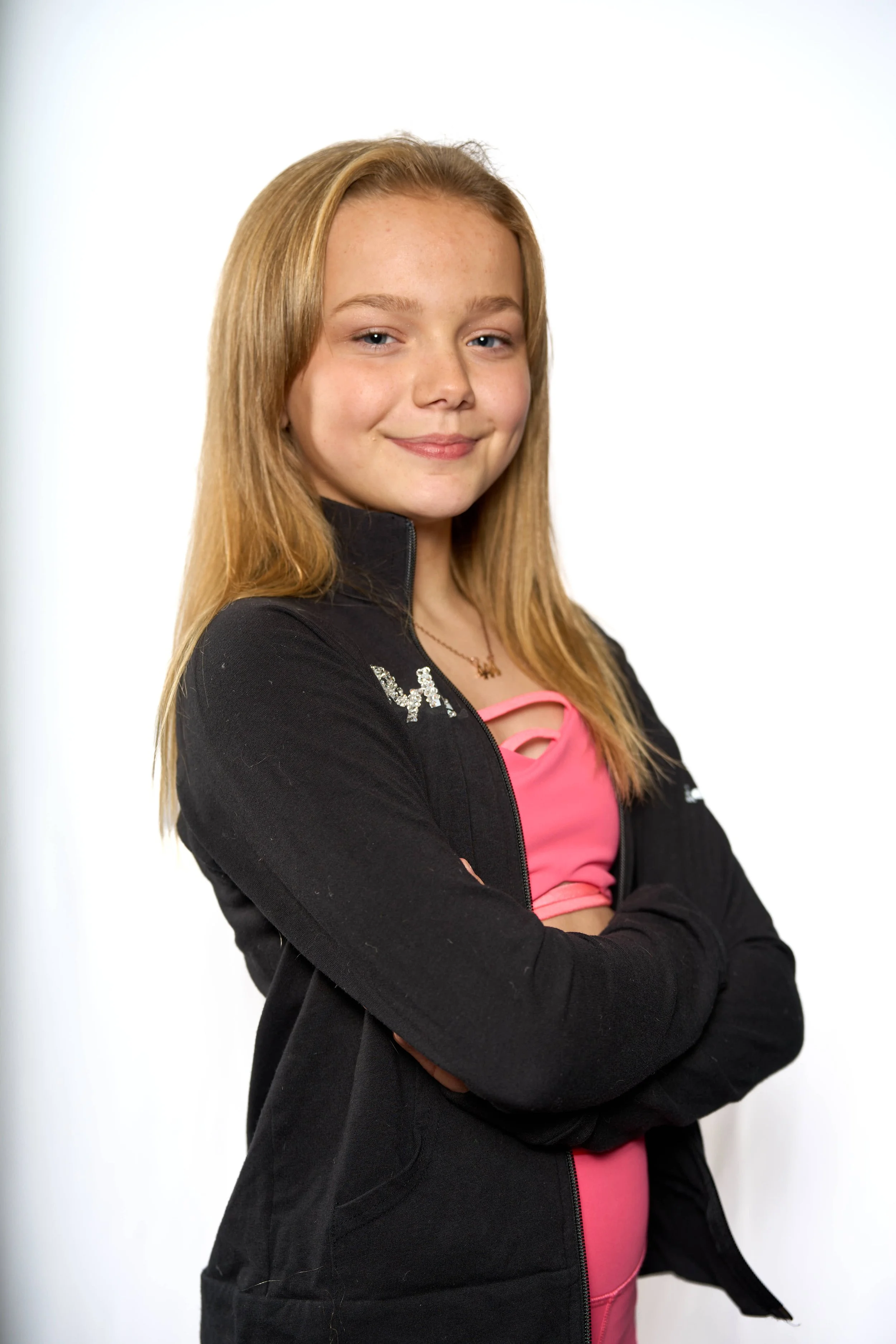 young dancer in pink top and black jacket poses for confident headshot photograph by Life Times Photography