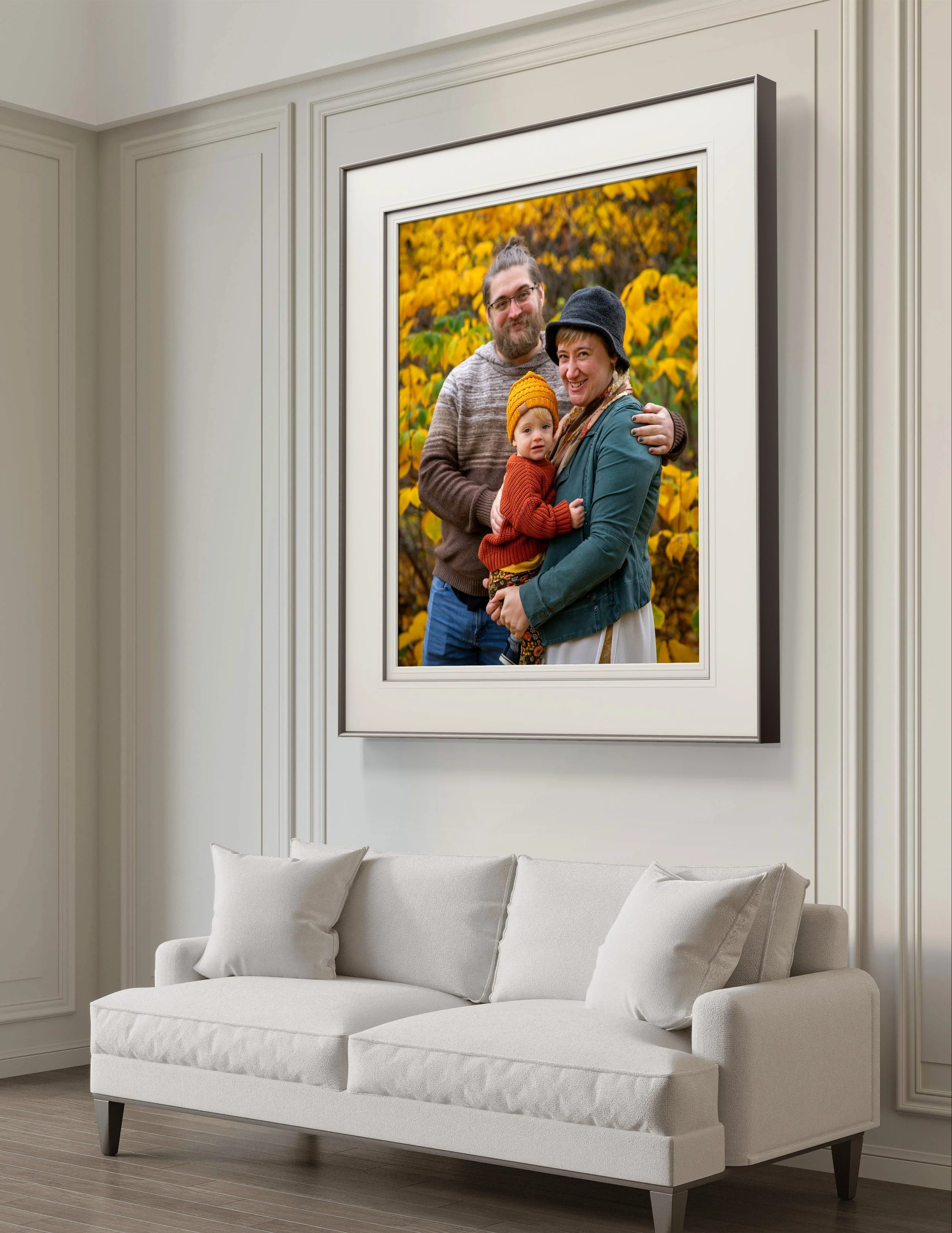 Living room with large family portrait on wall above a white sofa.