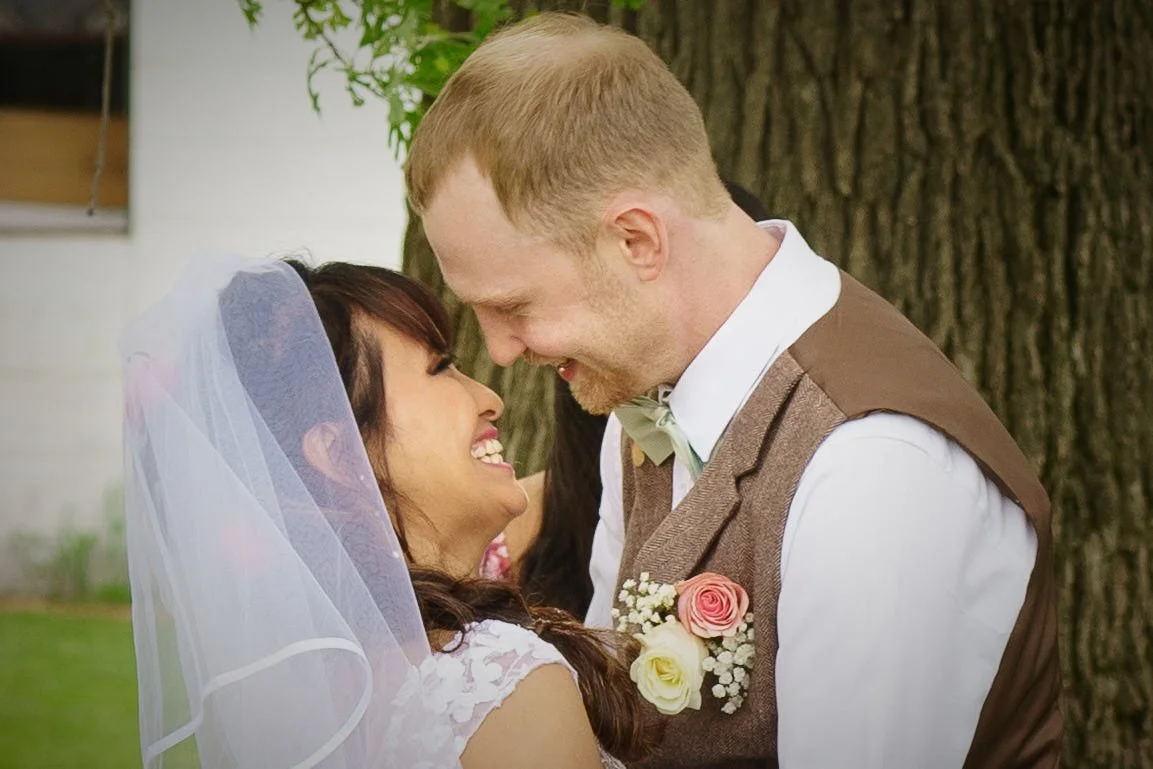 bride and groom lean in for kiss both smiling wide photograph by Life Times Photography