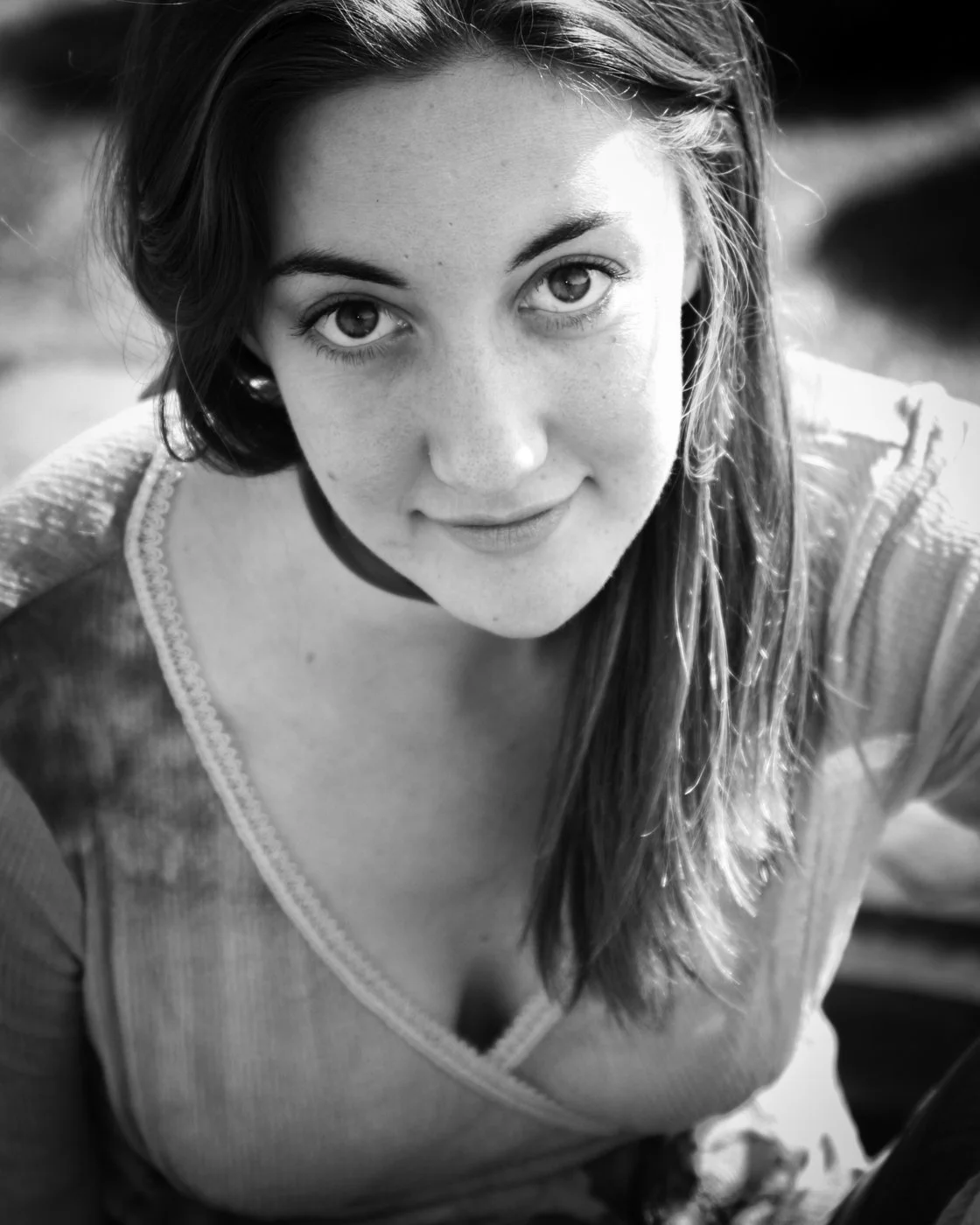 Close-up black and white photo of a young woman with long hair looking at the camera with a slight smile.