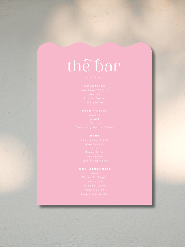 Pink bar menu board listing various cocktails, beers, wines, and non-alcoholic drinks.