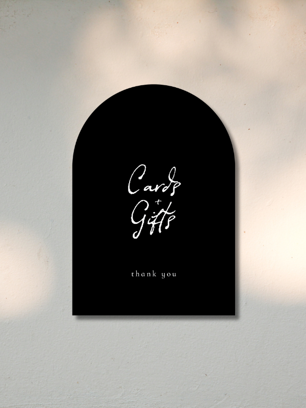 Black wall hanging with white handwritten text that says "Cards + Gifts" and smaller text below saying "thank you".