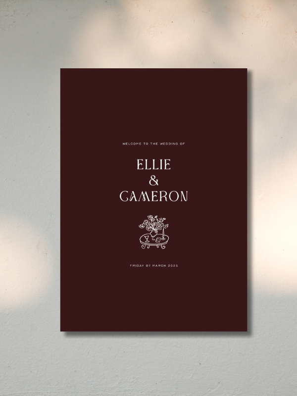 Wedding welcome sign with dark red background, white text reading "Welcome to the wedding of Ellie & Cameron" and the date "Friday 07 March 2025," with a small decorative tree and bench illustration.