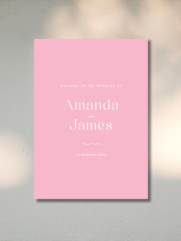 Pink wedding welcome sign with white text, reading 'Welcome to the wedding of Amanda and James, 13 December 2023', attached to a textured wall.