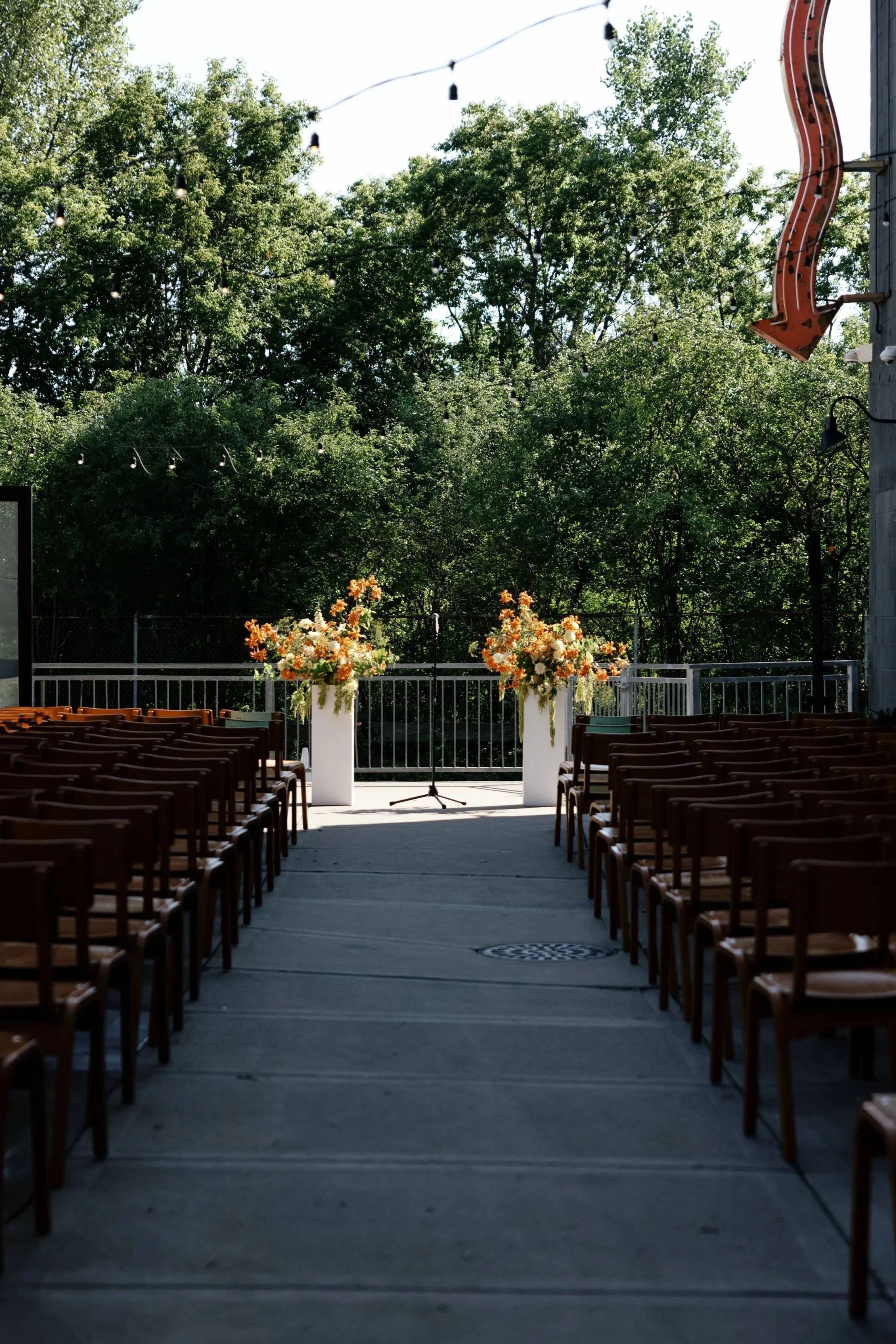 An outdoor wedding ceremony is set with chairs and flowers on a courtyard venue in St. Paul, Minnesota