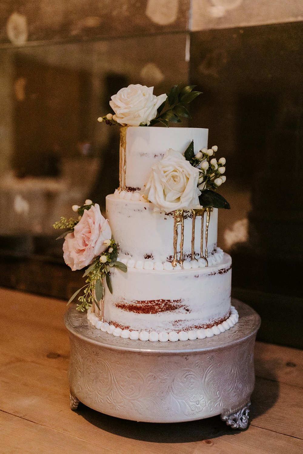 simple naked white boho wedding cake with white and pink flowers, photo by tida svy photography