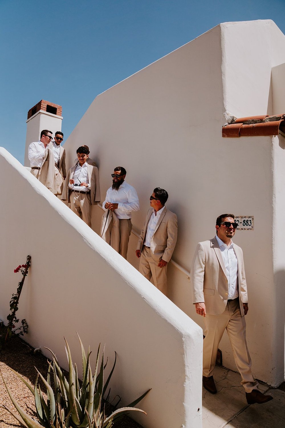 Groomsmen in tan suits on the stairs at La Quinta Resort in Palm Springs Wedding | Photo by Tida Svy