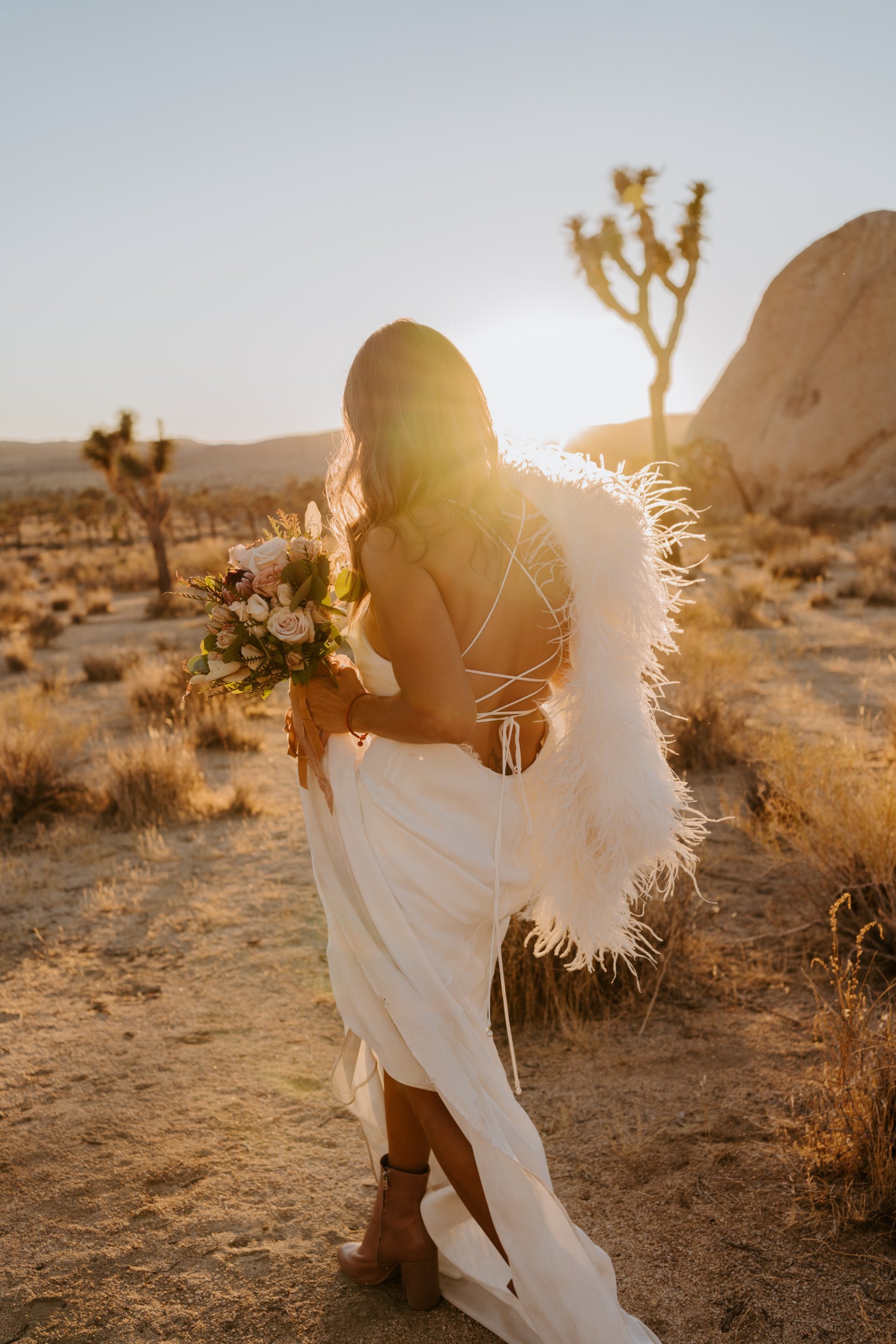 Stylish sunset Joshua Tree bridal style, Grace Loves Lace elegant simple silk strappy dress with faux fur shawl, Photo by Tida Svy