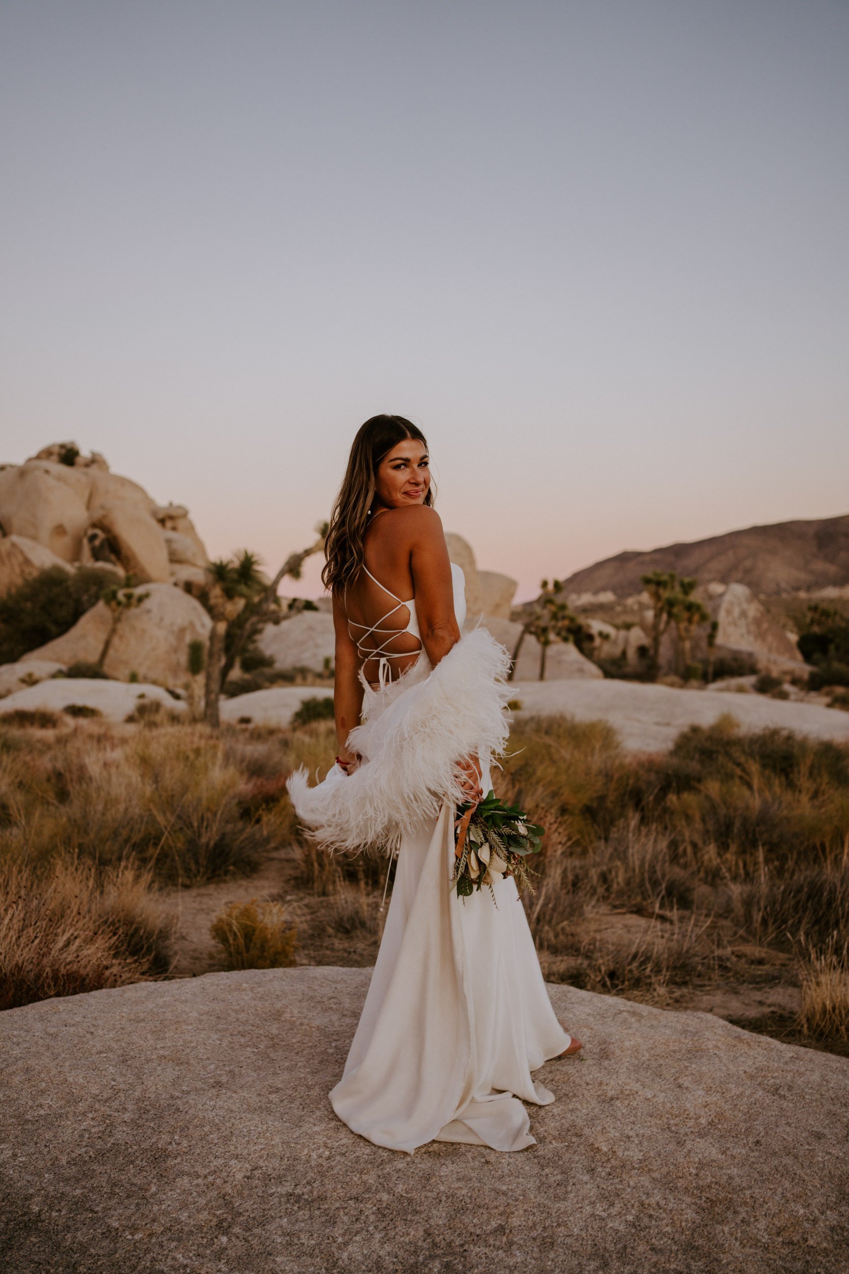 Stylish sunset Joshua Tree bridal style, Grace Loves Lace elegant simple silk strappy dress with faux fur shawl, Photo by Tida Svy