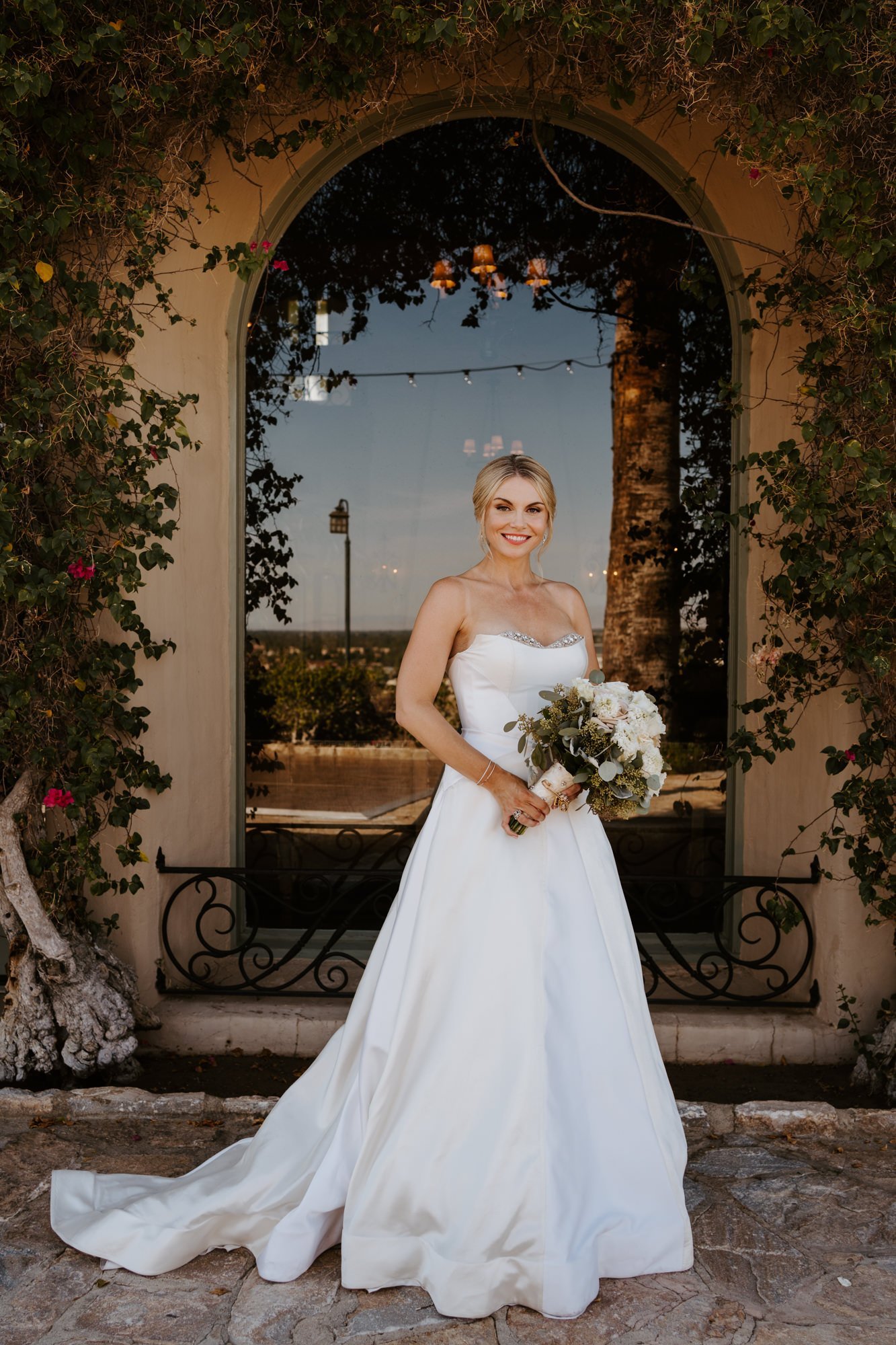 Elegant and classic bride in white strapless A Line gown and white bouquet at The O’Donnell House wedding in Palm Springs