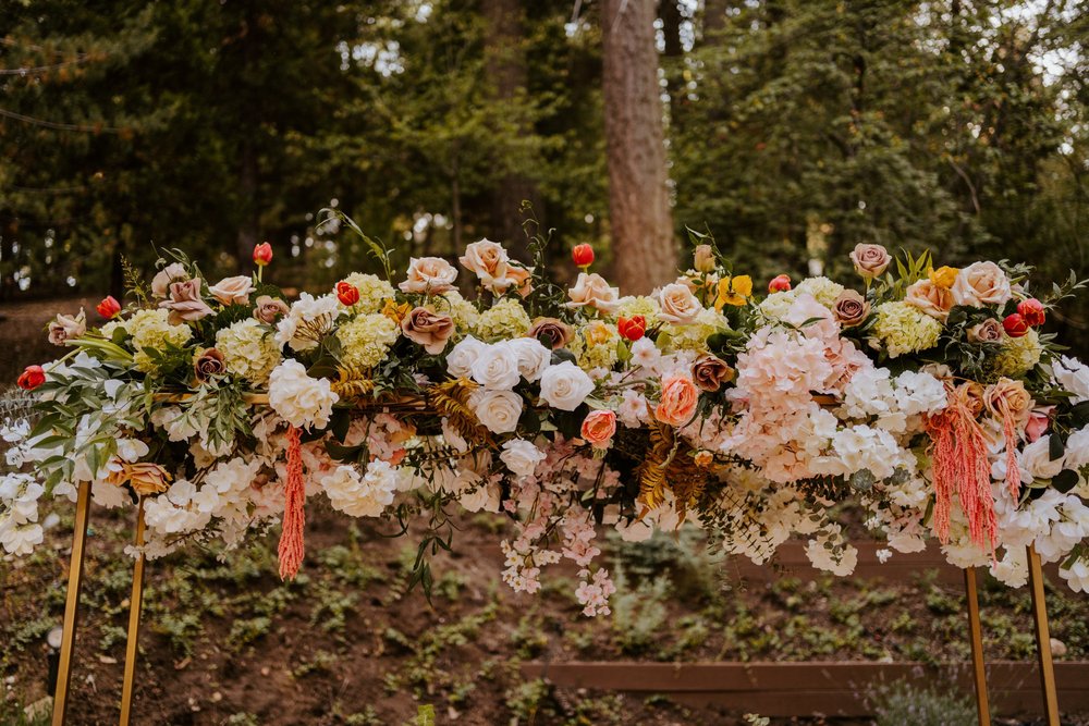 Enchanted forest castle wedding at Castle in the Forest in Lake Arrowhead, magical castle airbnb wedding, long bridal party head table, floating cloud floral centerpiece, photography by Tida Svy