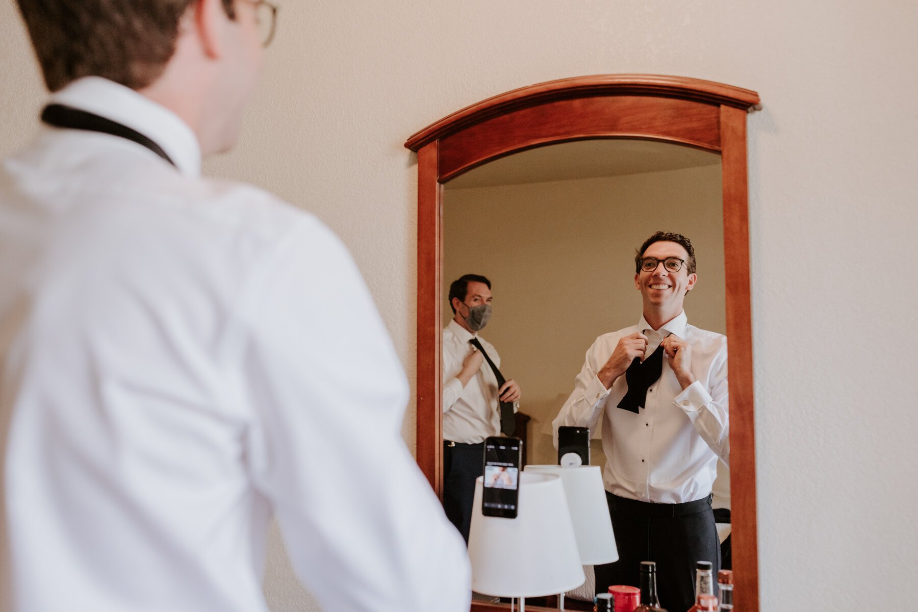  Groom getting ready in mirror tying bow tie, Palm Springs Wedding Photographer | Palm Mountain Resort and Spa | Tida Svy Photography 