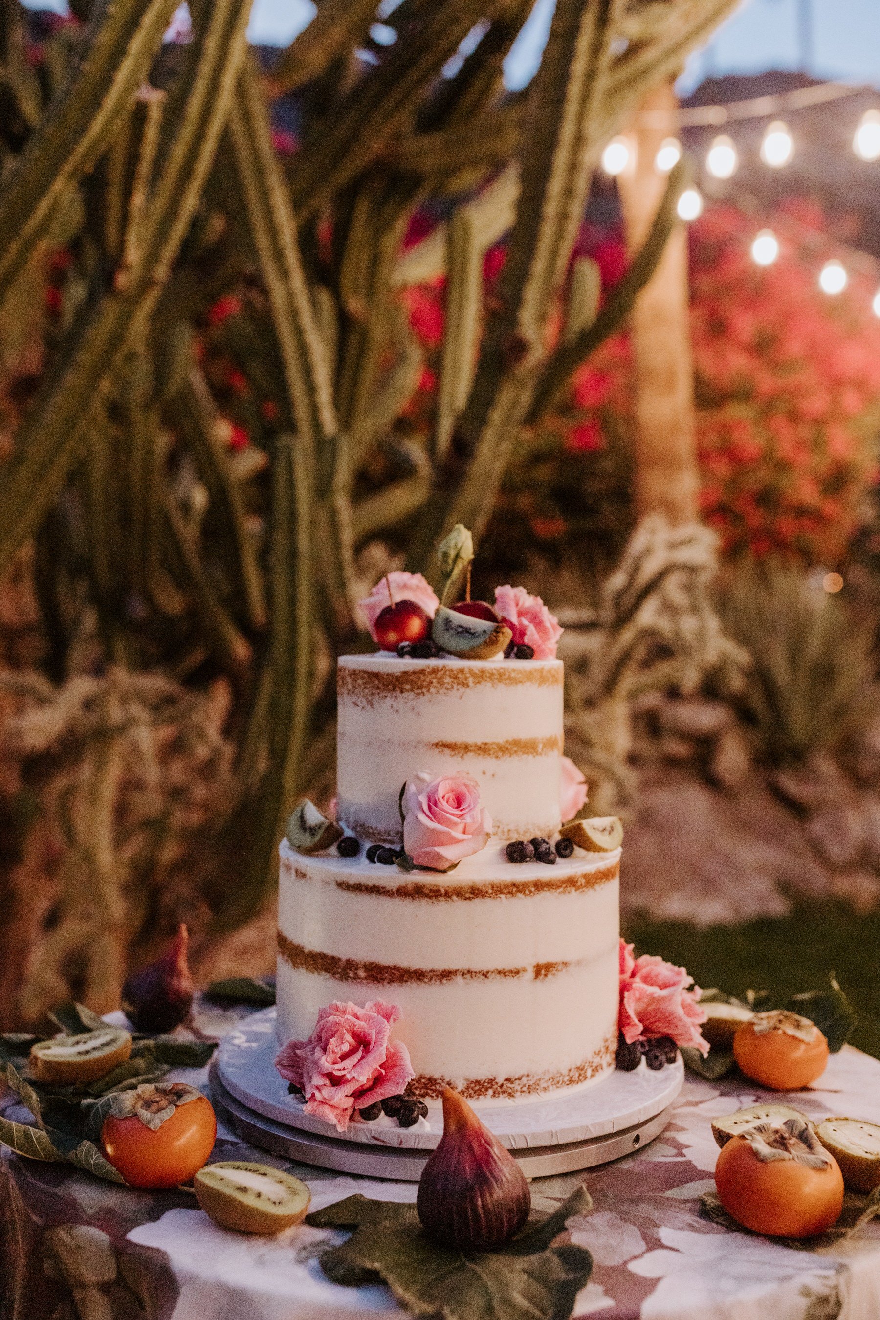 White naked layered wedding cake with figs, fruit, and citrus, Palm Springs Wedding, Photography by Tida Svy