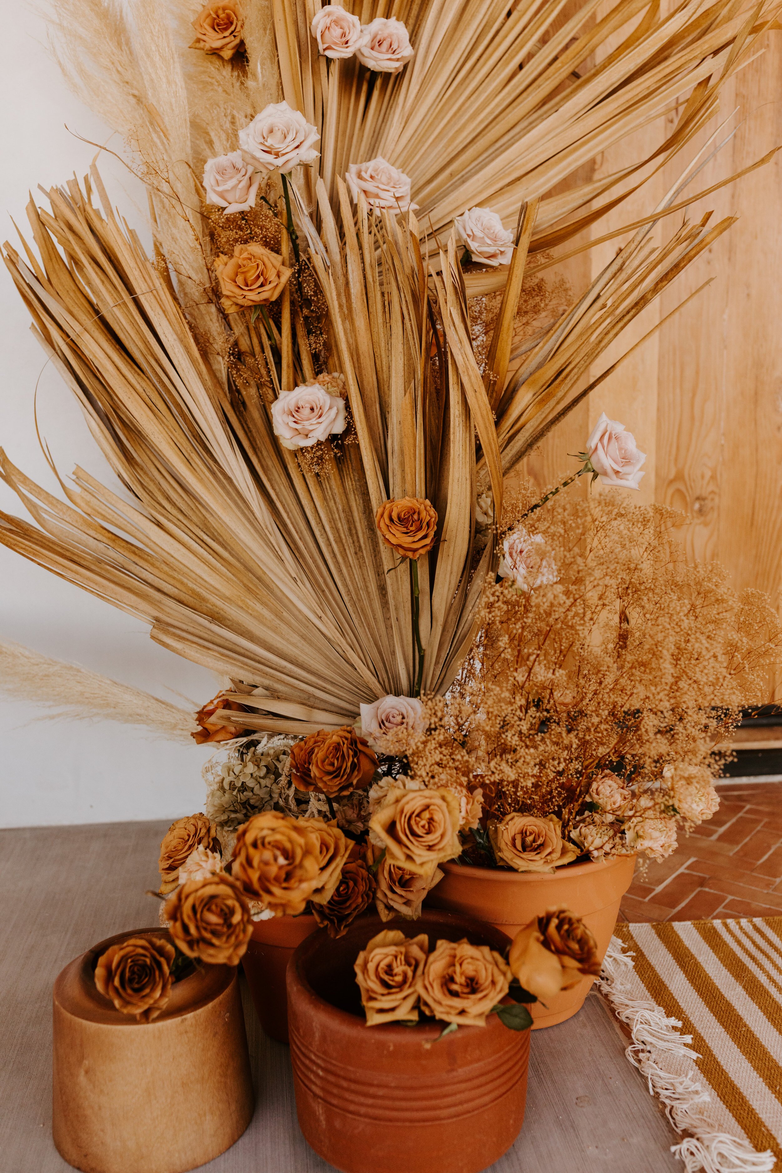 Dried palm leaves rust and neutral color palette wedding arch | Joshua Tree Elopement | Florals by Cultivated by Faith | Photo by Tida Svy | www.tidasvy.com