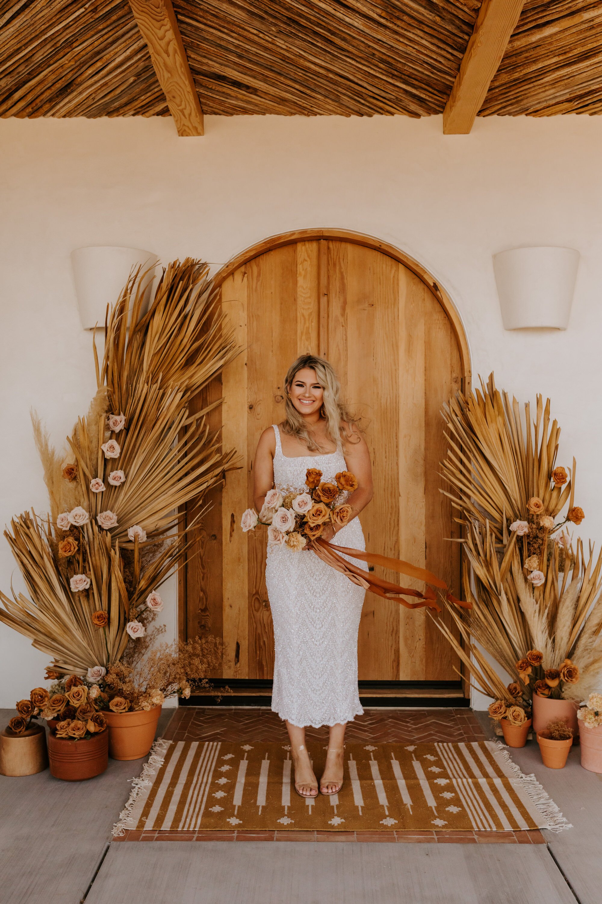 Boho Joshua Tree elopement at Desert Wild JT airbnb | Dried palm leaves, pampas grass, neutral rust florals | Tida Svy | www.tidasvy.com