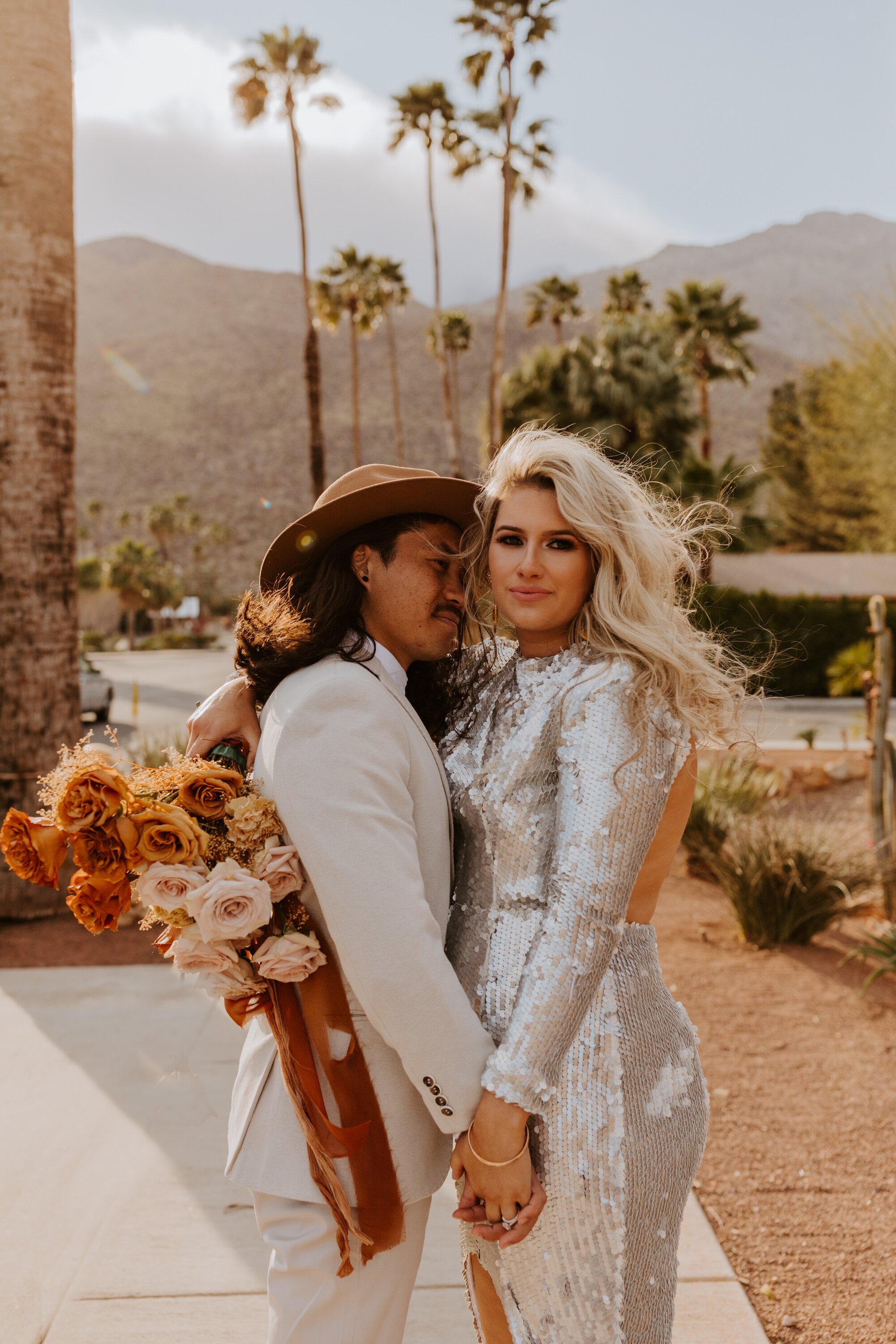 Palm Springs elopement | Silver sequin wedding dress | Beige groom suit with rust fedora | Neutral ombre bouquet with rust ribbon | Palm Springs Wedding Photographer | Tida Svy | www.tidasvy.com