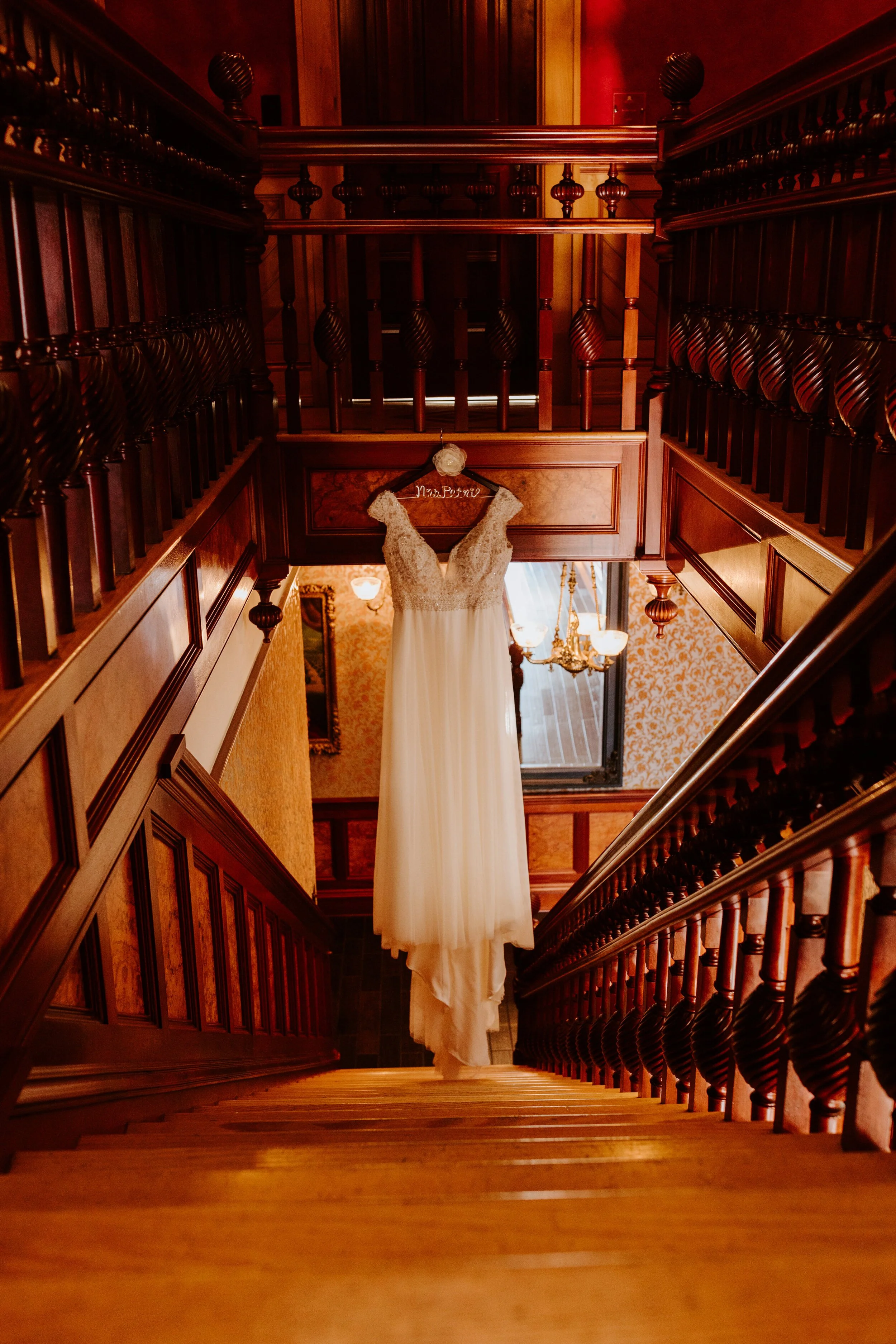 Dress hanging on staircase | Newhall Mansion Wedding | Piru, CA | Southern California Wedding Photographer | Photo by Tida Svy | www.tidasvy.com