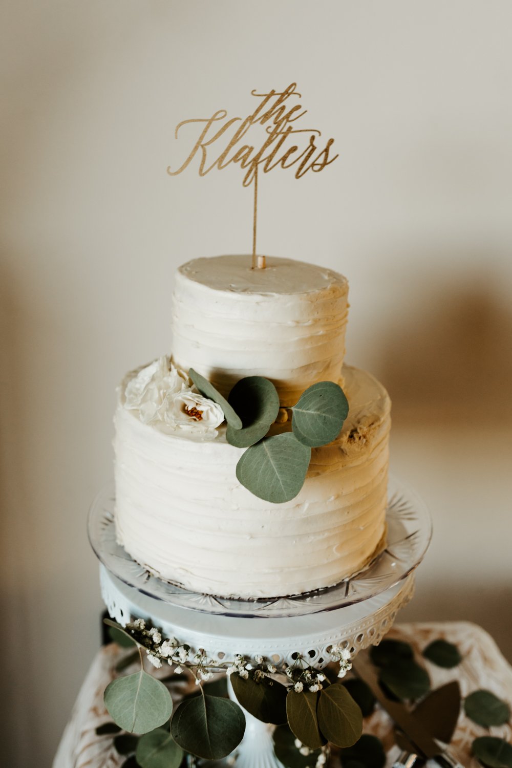 Clean simple modern white wedding cake with eucalyptus | Joshua Tree Wedding Photographer | JT Serenity Escape Airbnb Wedding | Tida Svy | www.tidasvy.com