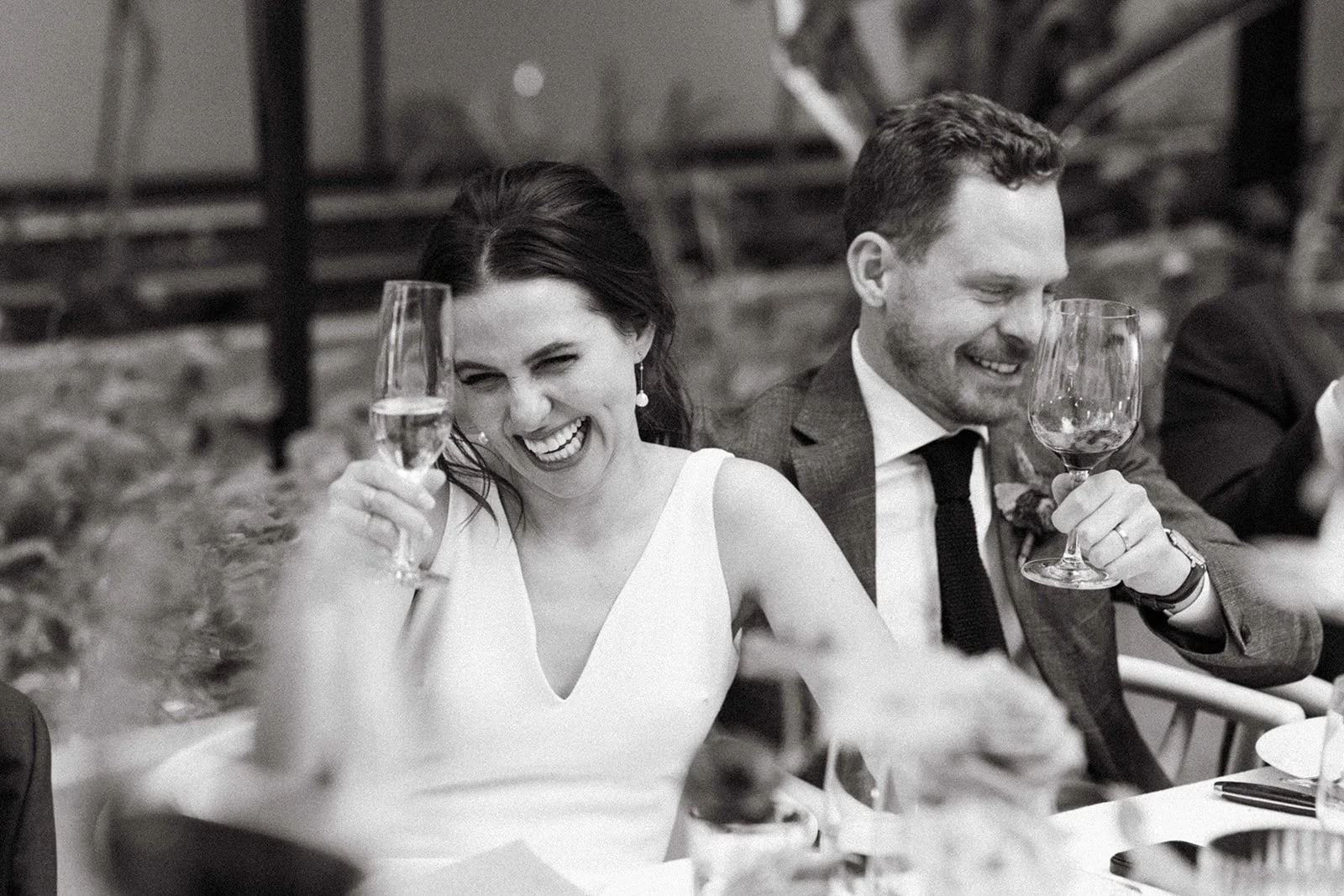 black and white photo of a couple giving a toast at their wedding reception in palm springs