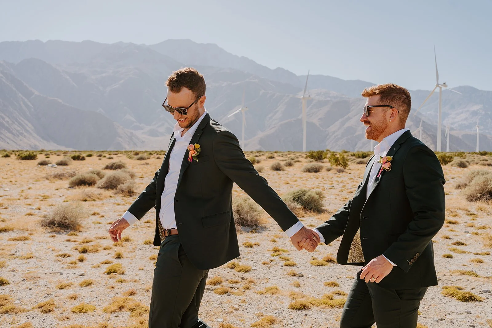 Gay couple holding hands during wedding portraits at the Palm Springs windmills LGBTQ wedding photographer Tida Svy
