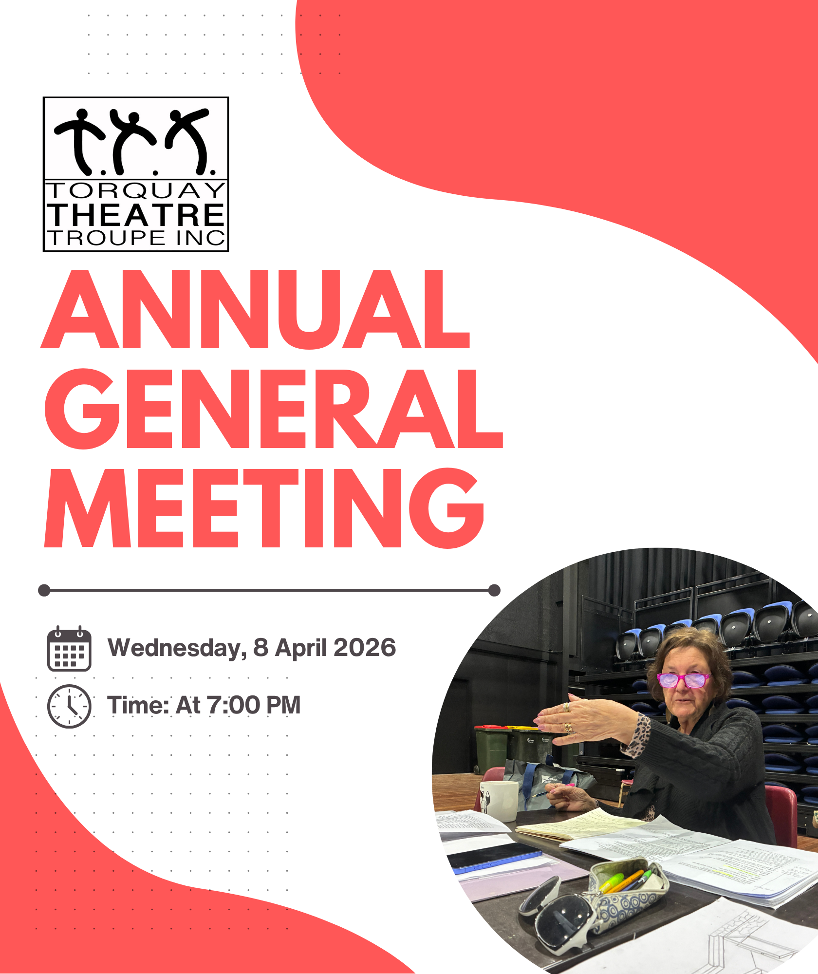 Image of a female in a directors chair at a desk pointing to the actors on stage
