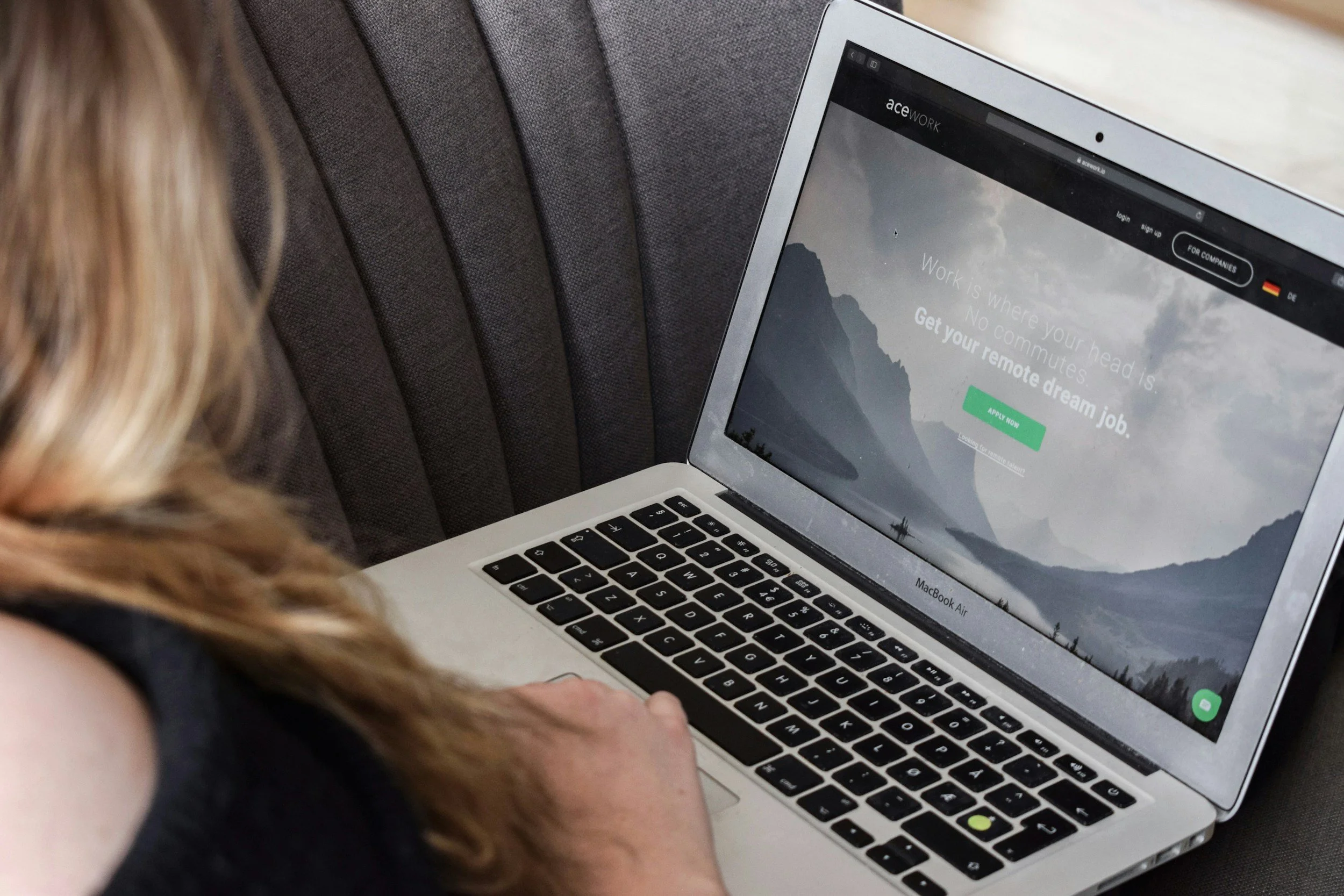 Female brown hair looking at laptop displaying website home page