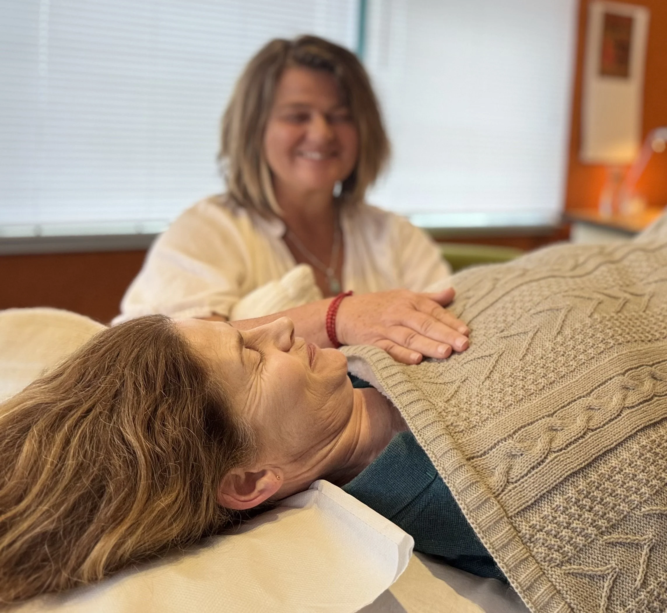 Resting hand over client lying on couch biodynamic craniosacral treatment