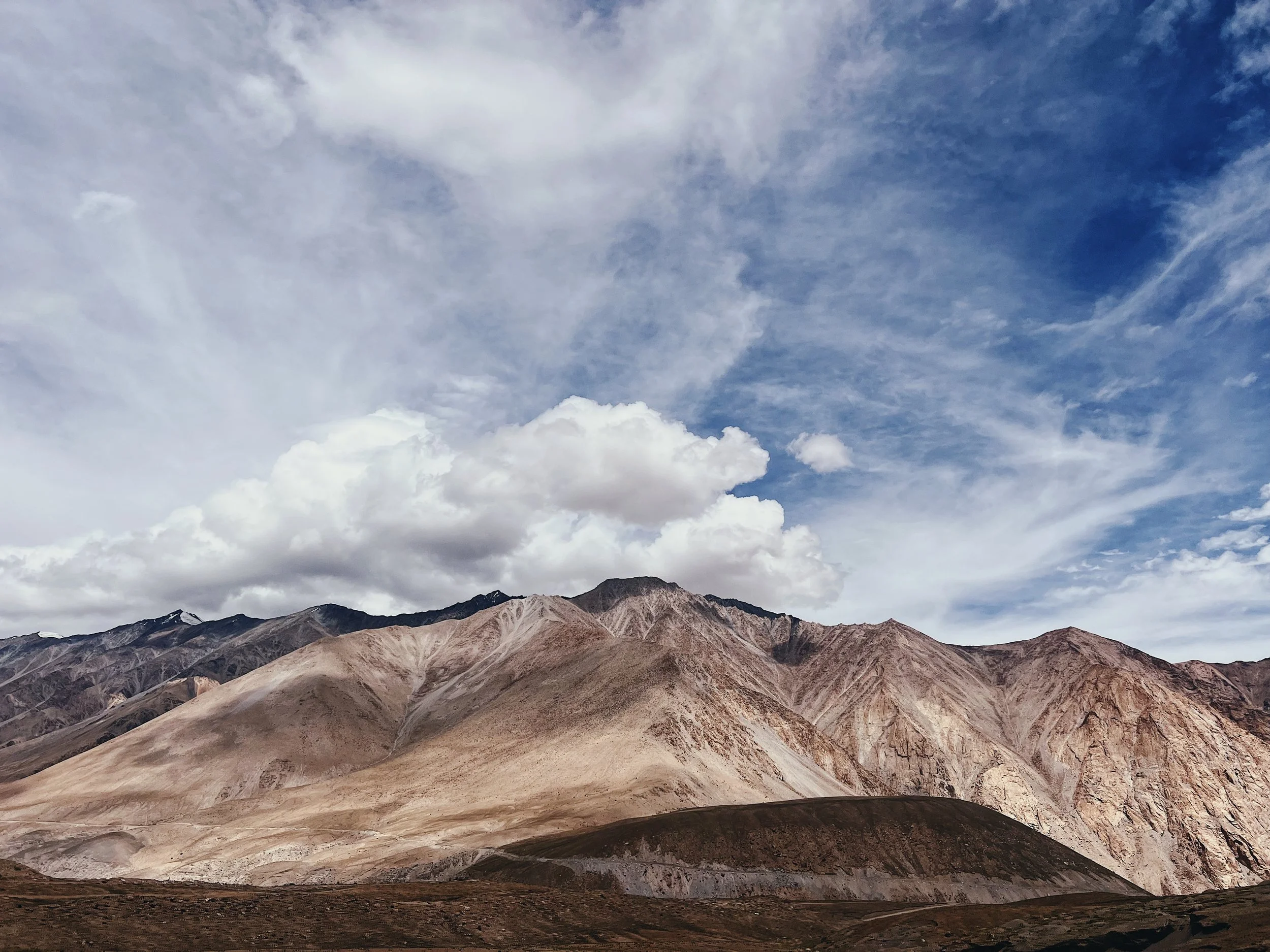 Scenic view of mountain range with a cloudy sky overhead in Ladakh.