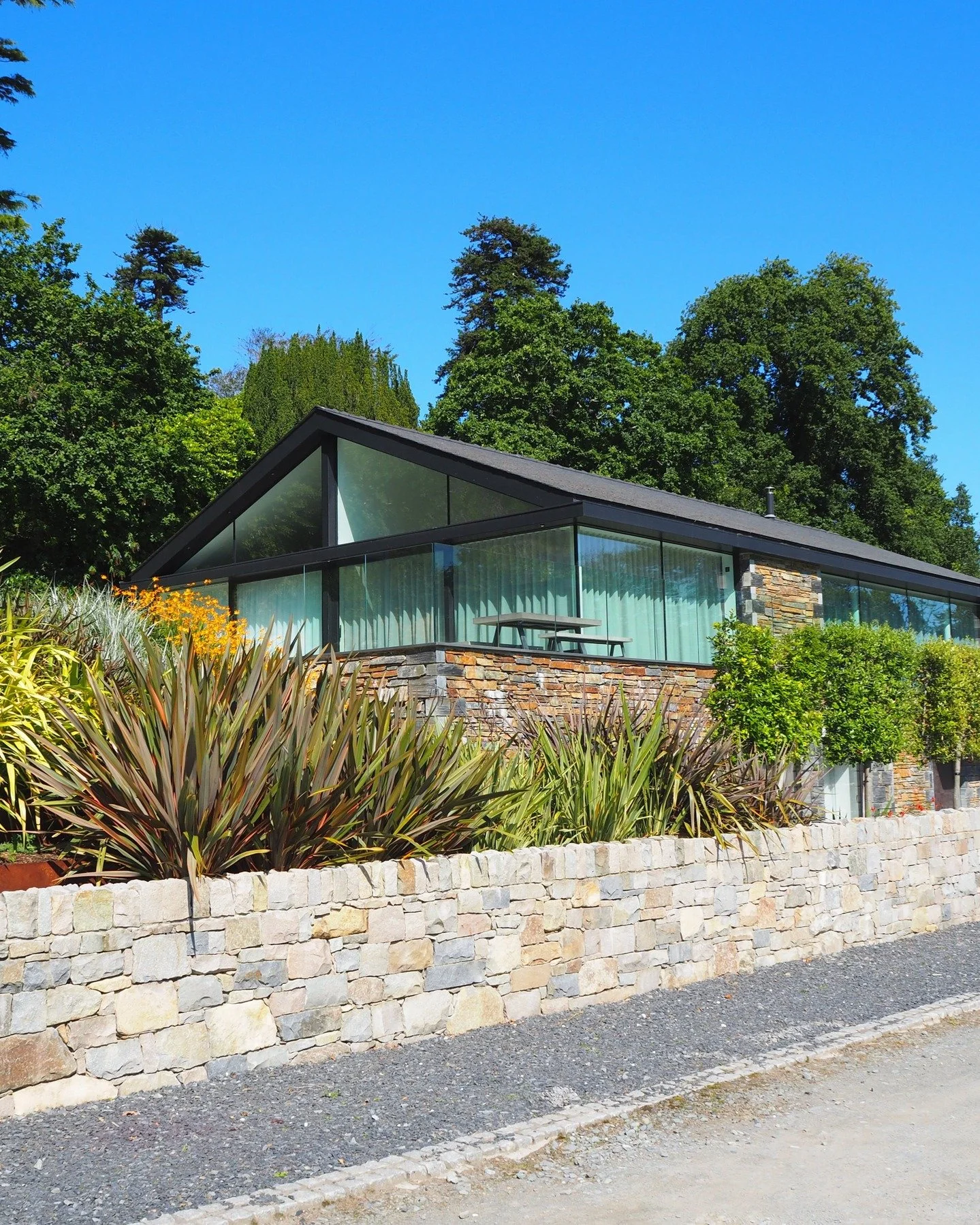 Throwback to this incredible new build we designed and delivered in North Wales! 🏡✨ With its Welsh stone fa&ccedil;ade and sleek glazed exterior, this home seamlessly integrates into its natural surroundings. A contemporary design that truly embrace