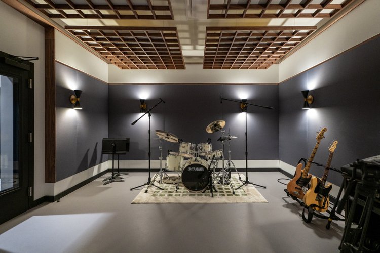 A rehearsal studio with a drum kit and guitars