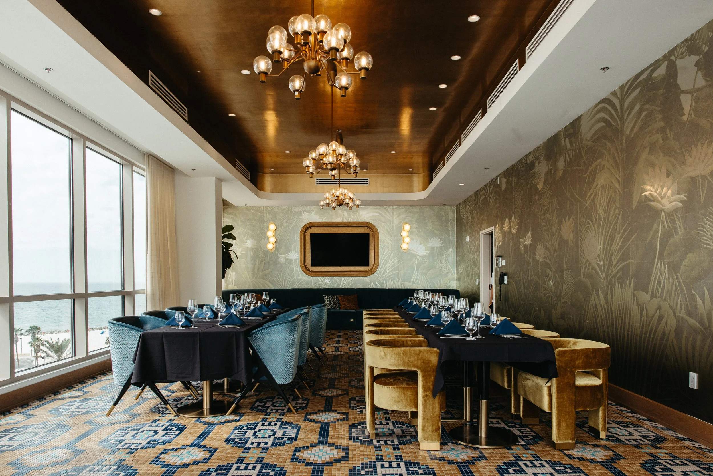 Luxurious private dining space featuring blue and gold velvet chairs.