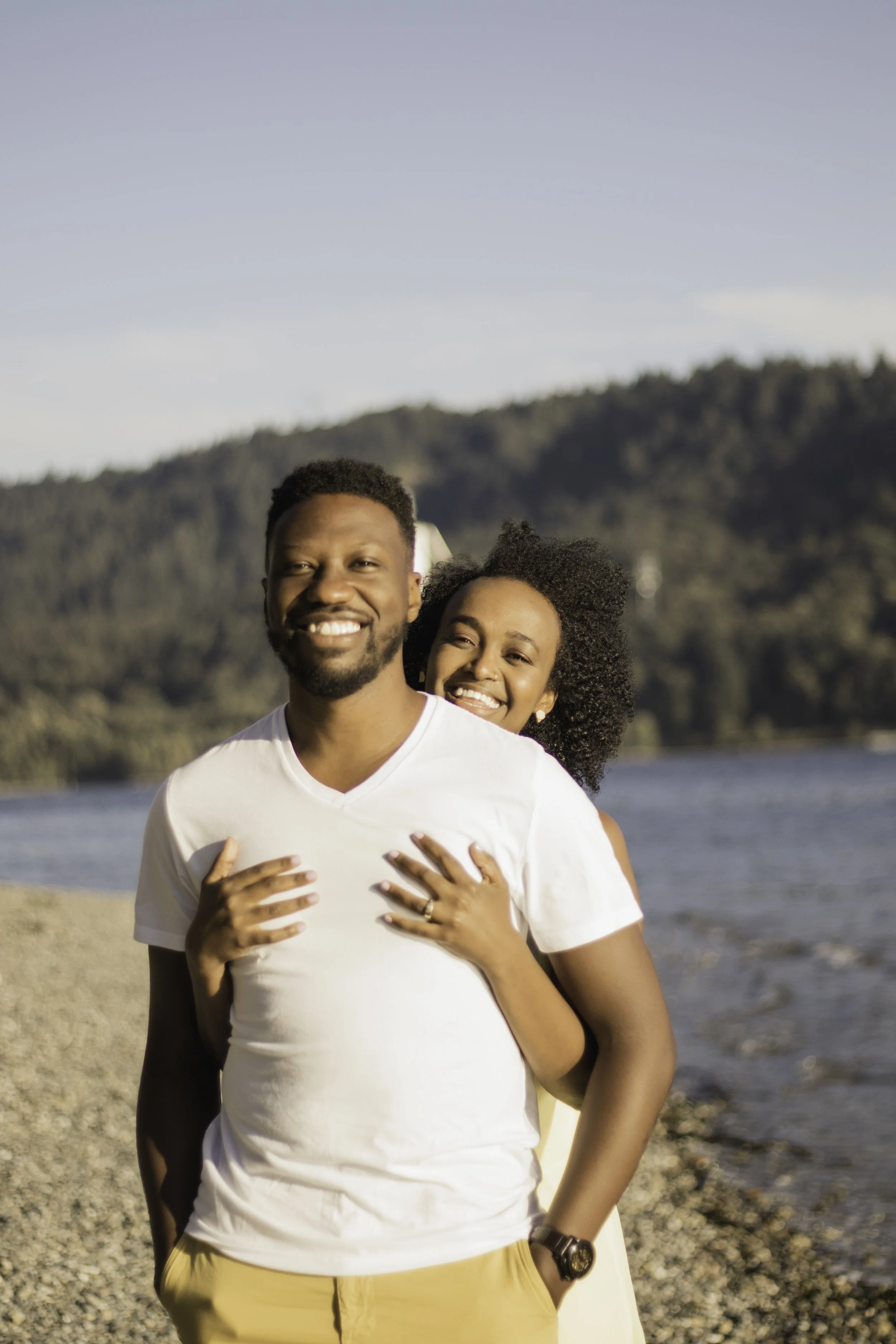 Ona Events smiling couple embracing at a beach in North Vancouver following a sunset proposal planned by Ona Events, Vancouver event planner