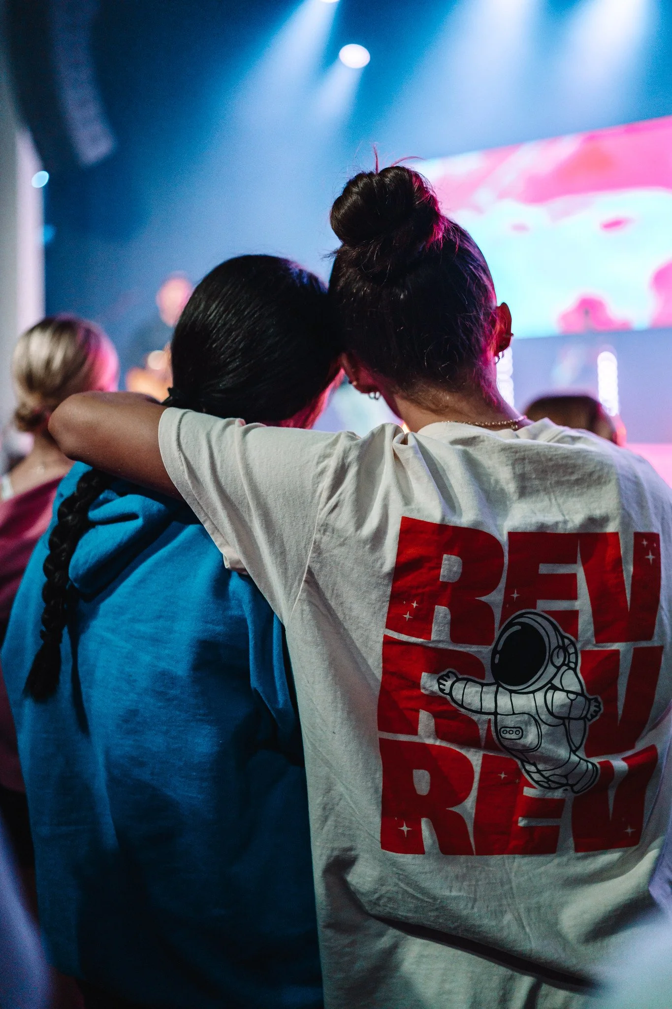 Two students with arms around each other at a REV night