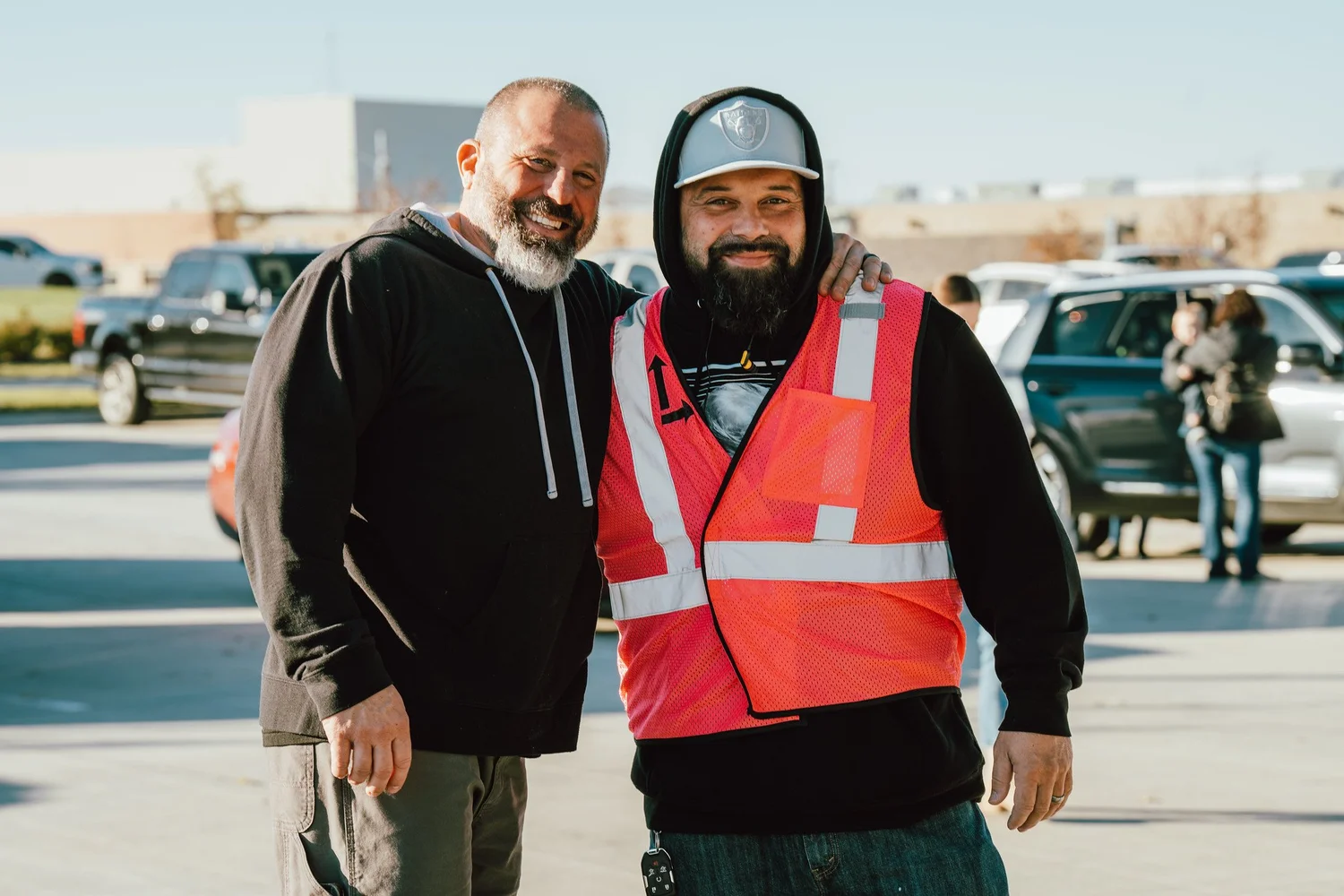 Two Guest Experience volunteers smiling in the parking lot