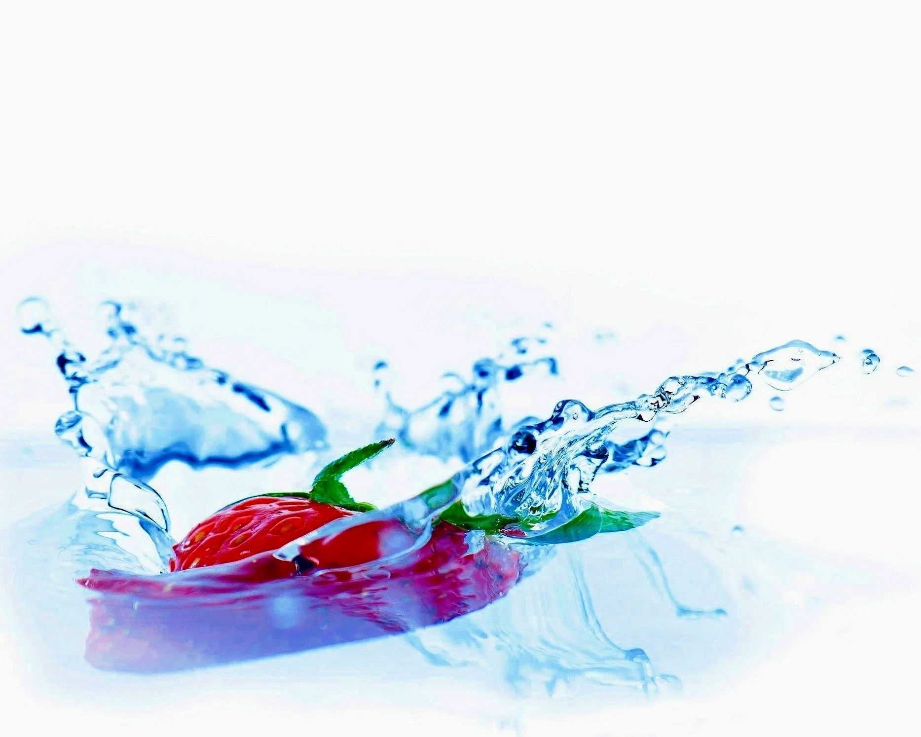 Strawberry splashing into water with droplets
