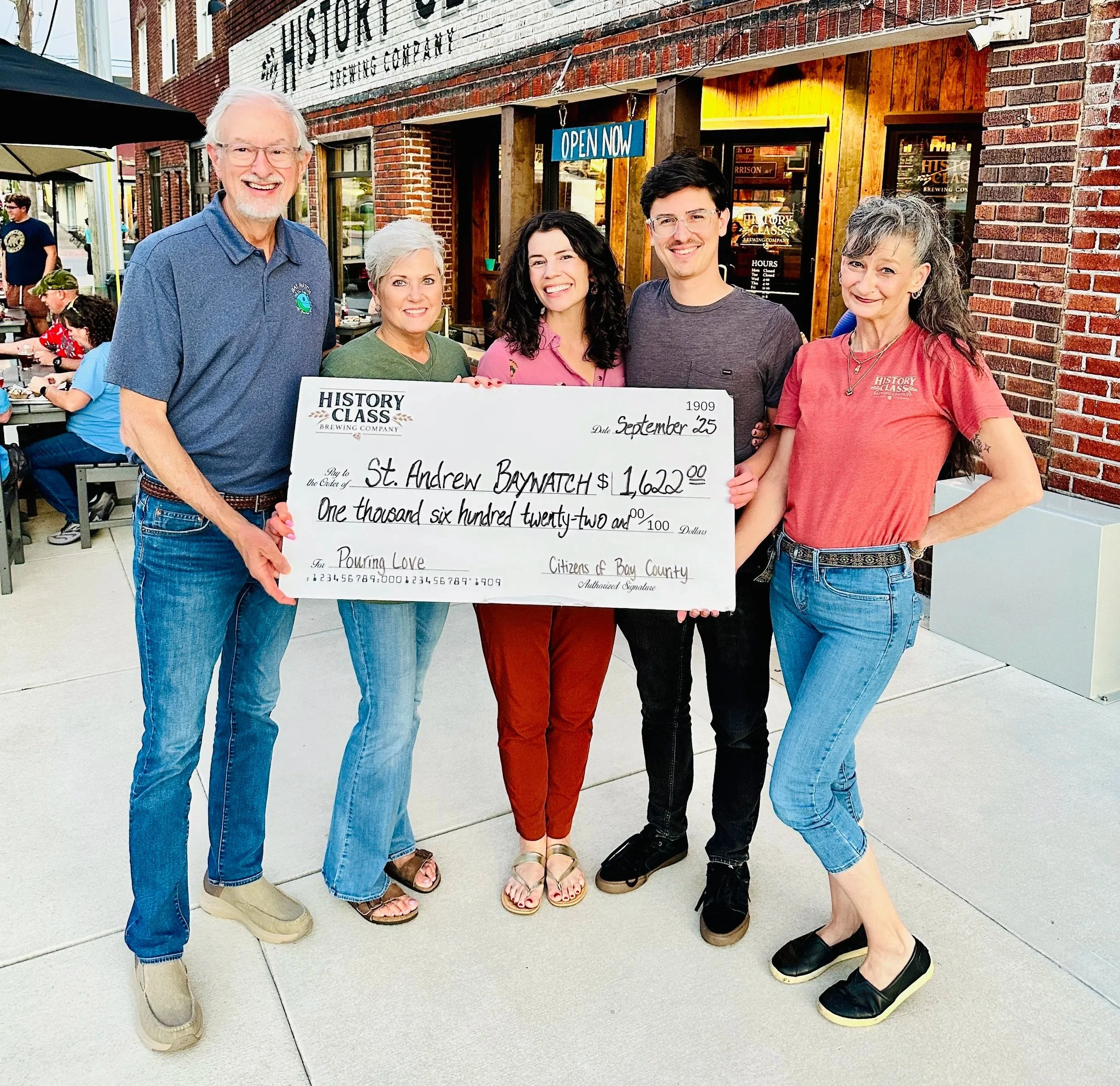 staff presenting check to charity
