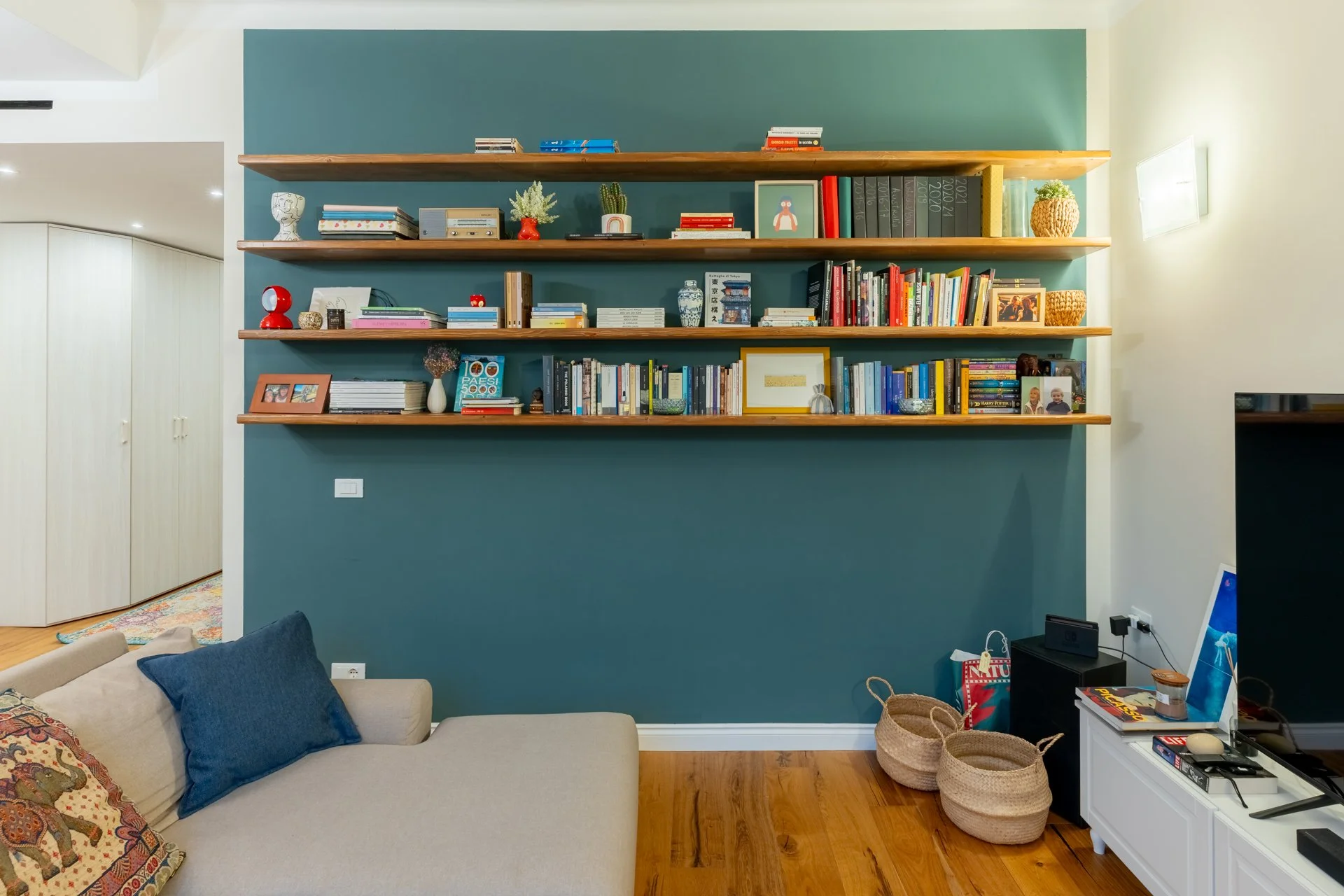 Scaffale con libri e decorazioni in soggiorno con parete blu
