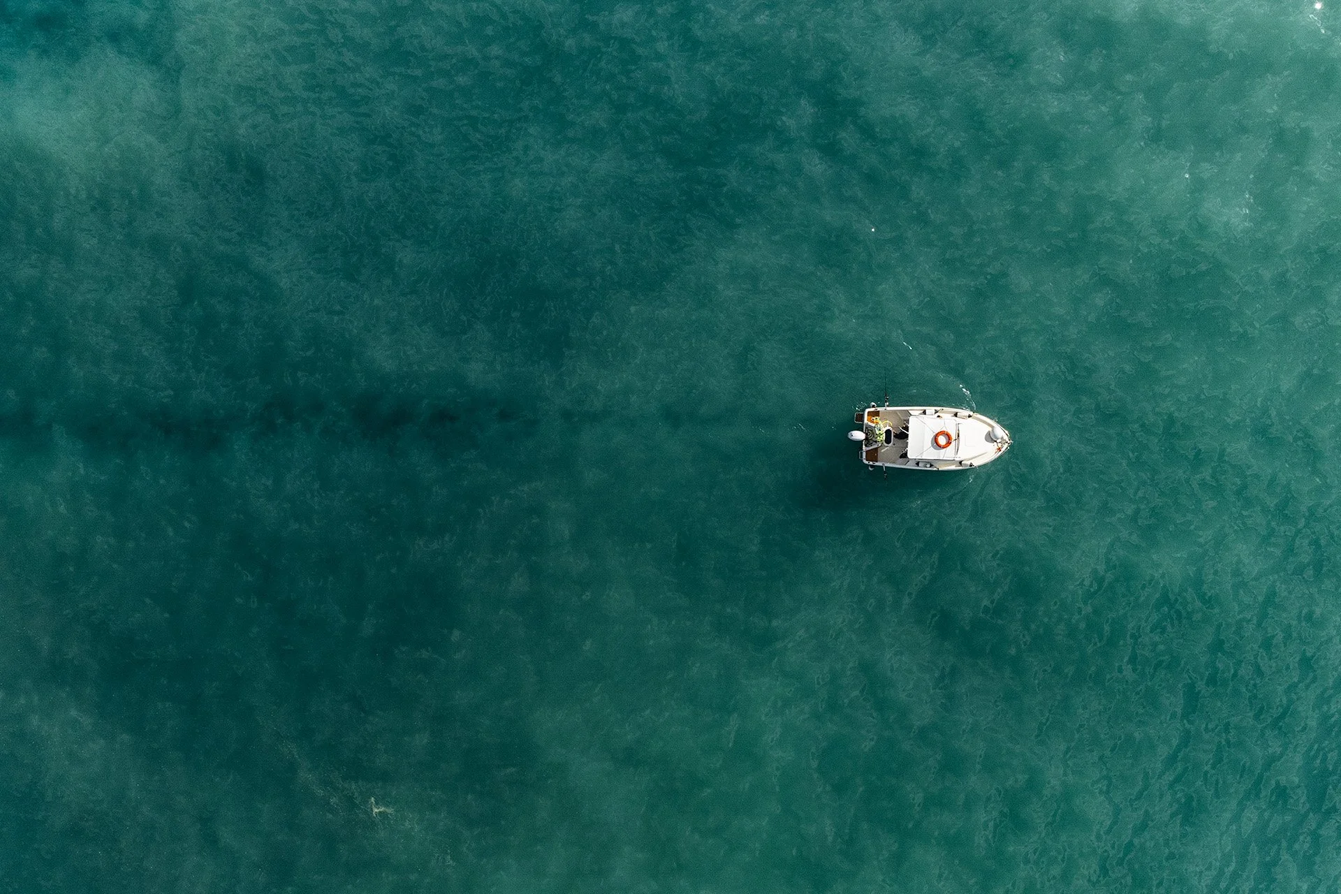Veduta aerea di una barca a motore in mare aperto, con scia dietro di essa