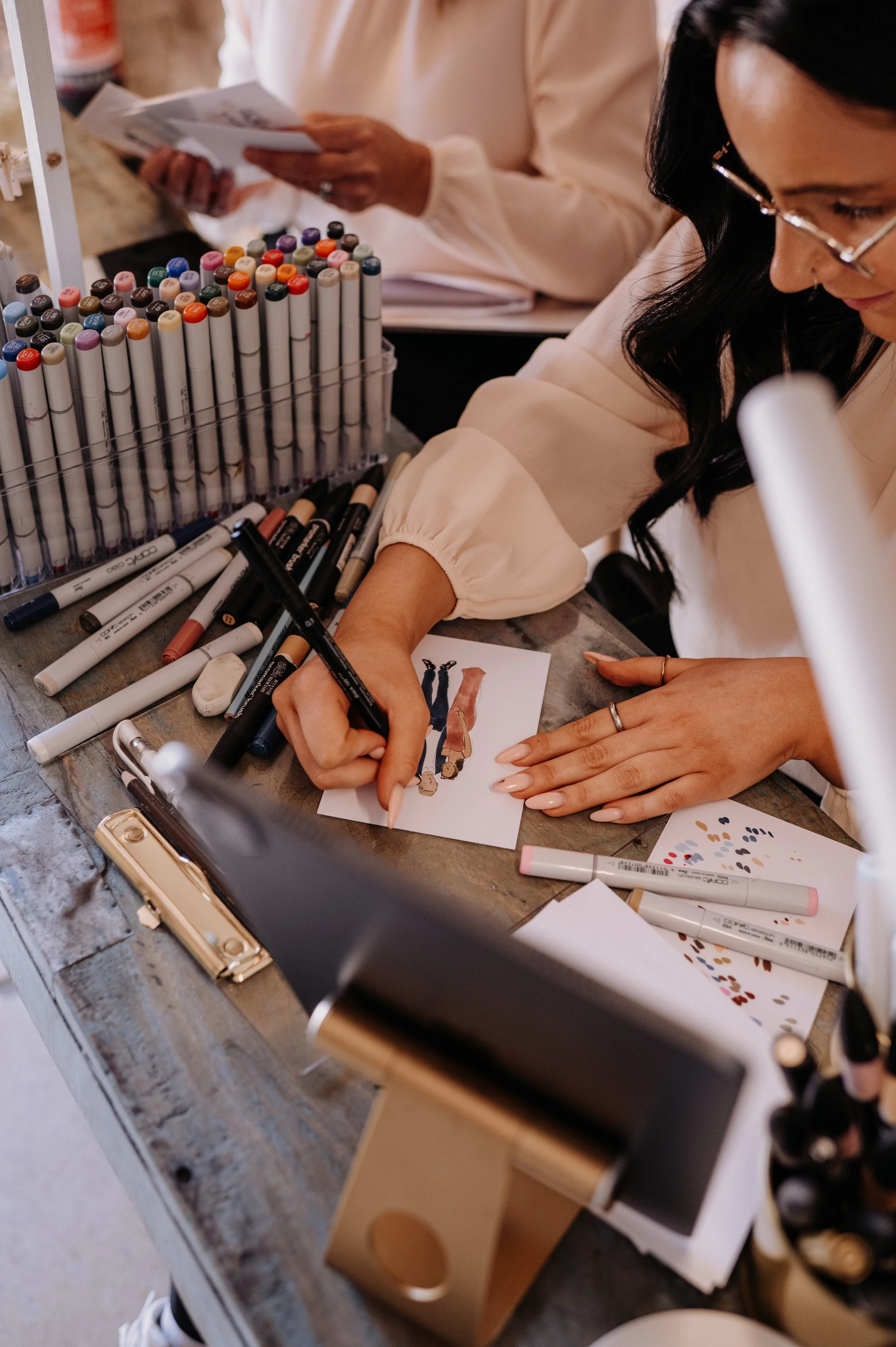 live wedding illustrator sketching guest portrait using reference photo