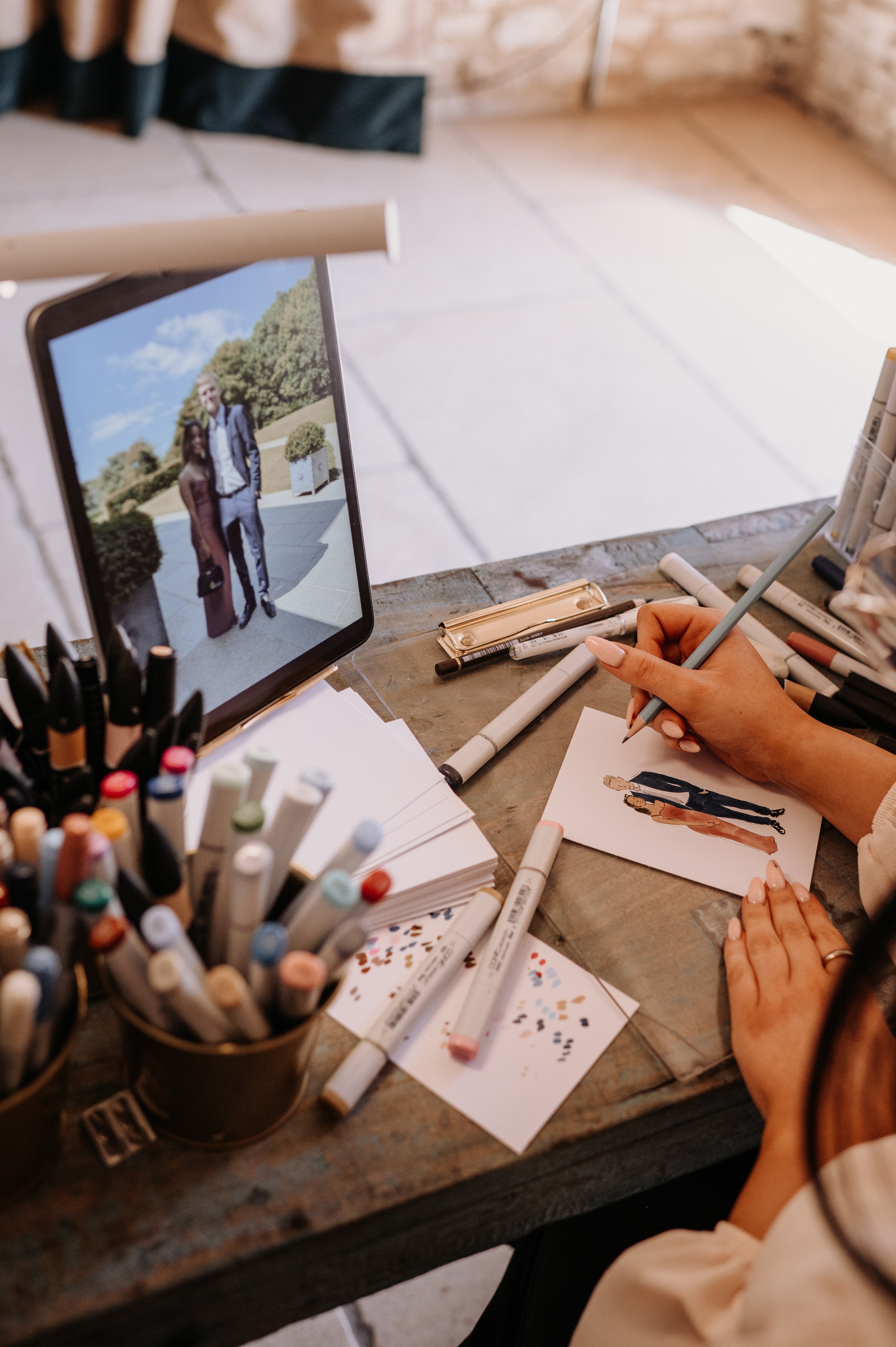 live wedding illustrator sketching guest portrait using reference photo