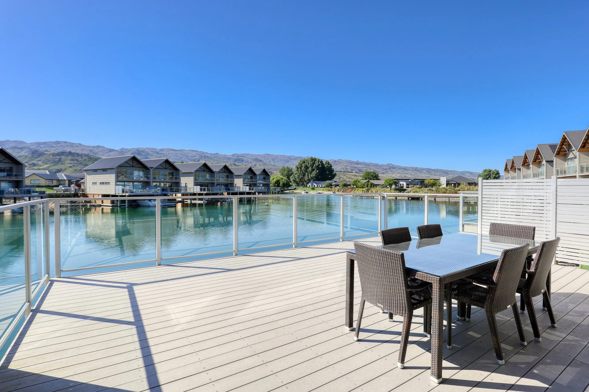 Family Villa at Lake Resort in Cromwell with a spacious waterfront deck, outdoor dining area, and views across Pisa Moorings.