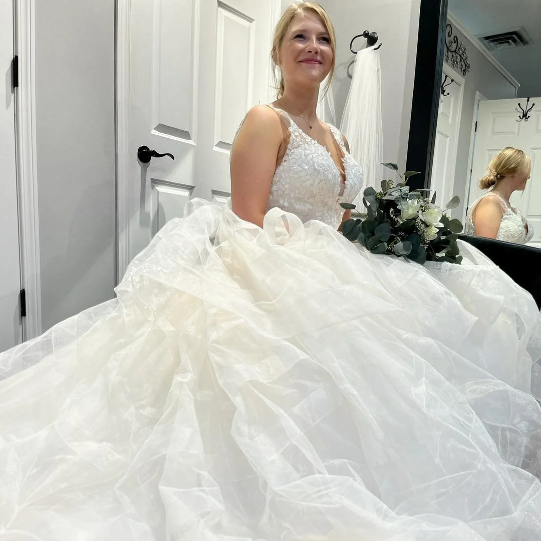 bride wearing wedding dress in bridal store