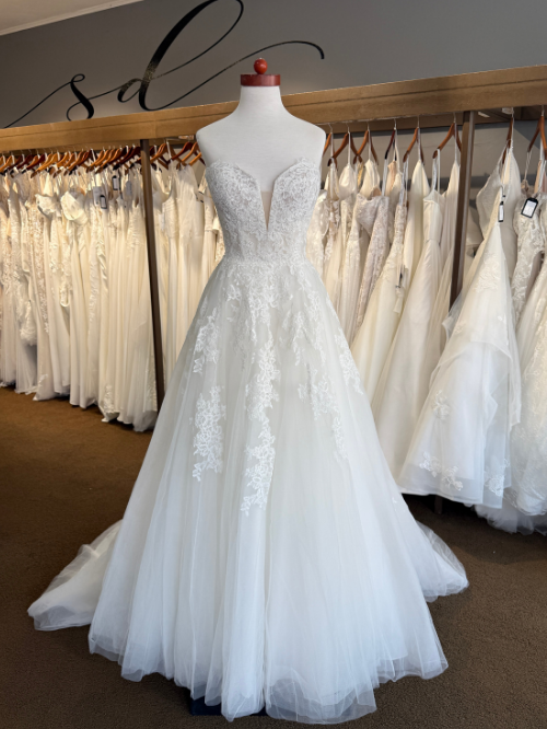 Lace ballgown on mannequin in front of wedding dresses