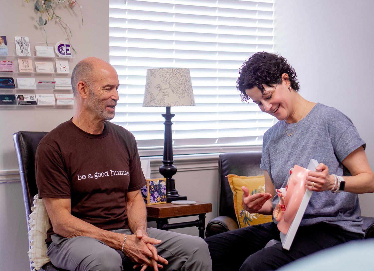 Jennifer Duggins, PT, using a pelvic model to explain anatomy to a seated patient