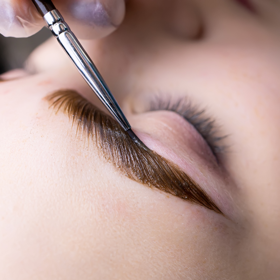 Close-up of eyebrow tinting with a brush