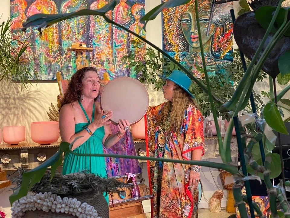 Lavender Grace Kent singing with a frame drum alongside a fellow cultural practitioner.